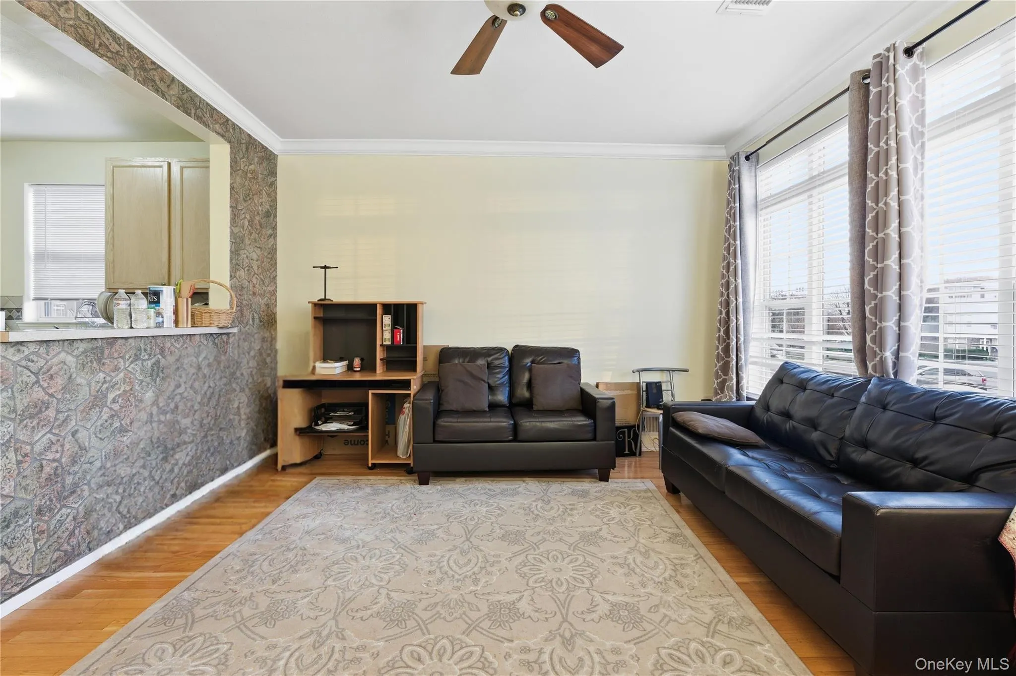Living area with crown molding, wood finished floors, and ceiling fan Living area with crown molding, wood finished floors, and ceiling fan