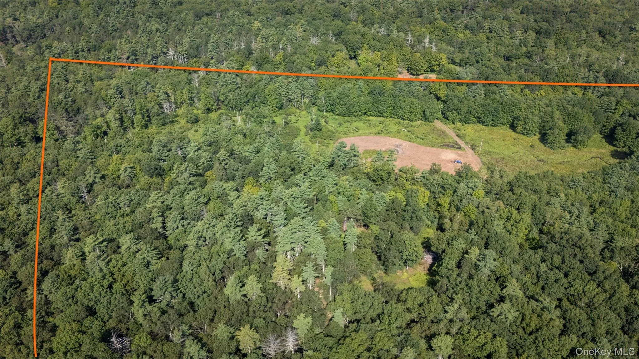 Aerial view of property and surrounding area featuring property boundaries highlighted and a heavily wooded area Aerial view of property and surrounding area featuring property boundaries highlighted and a heavily wooded area