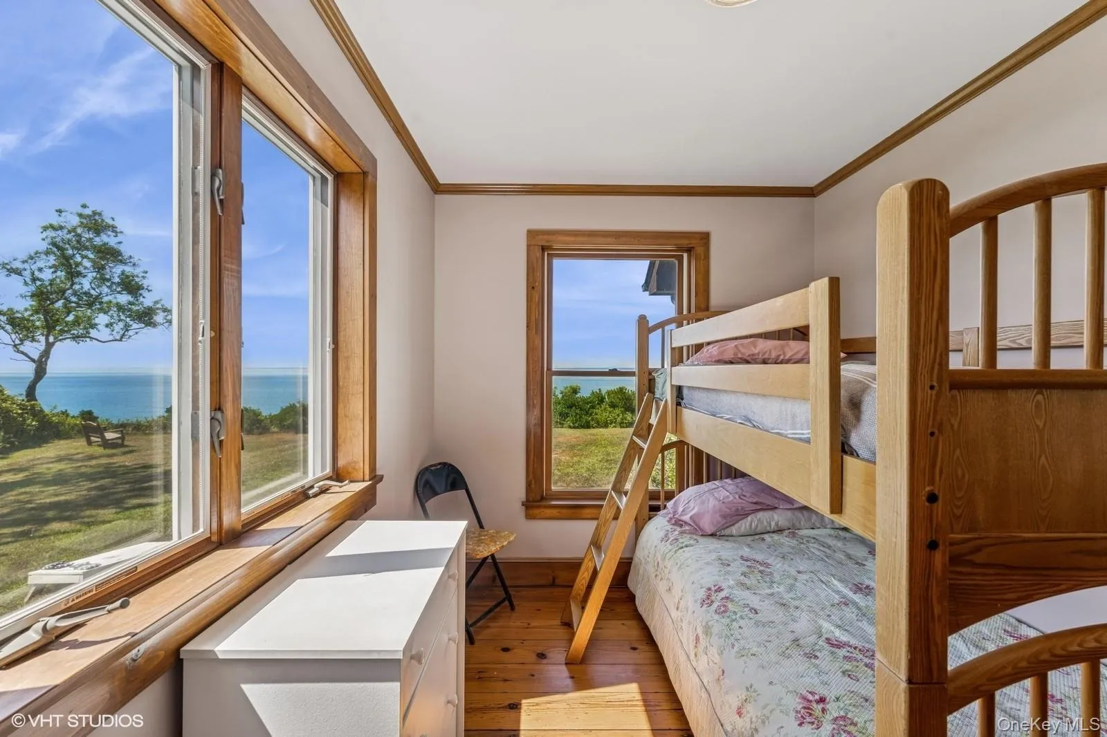 Bedroom with ornamental molding, dark wood-style flooring, and a water view Bedroom with ornamental molding, dark wood-style flooring, and a water view