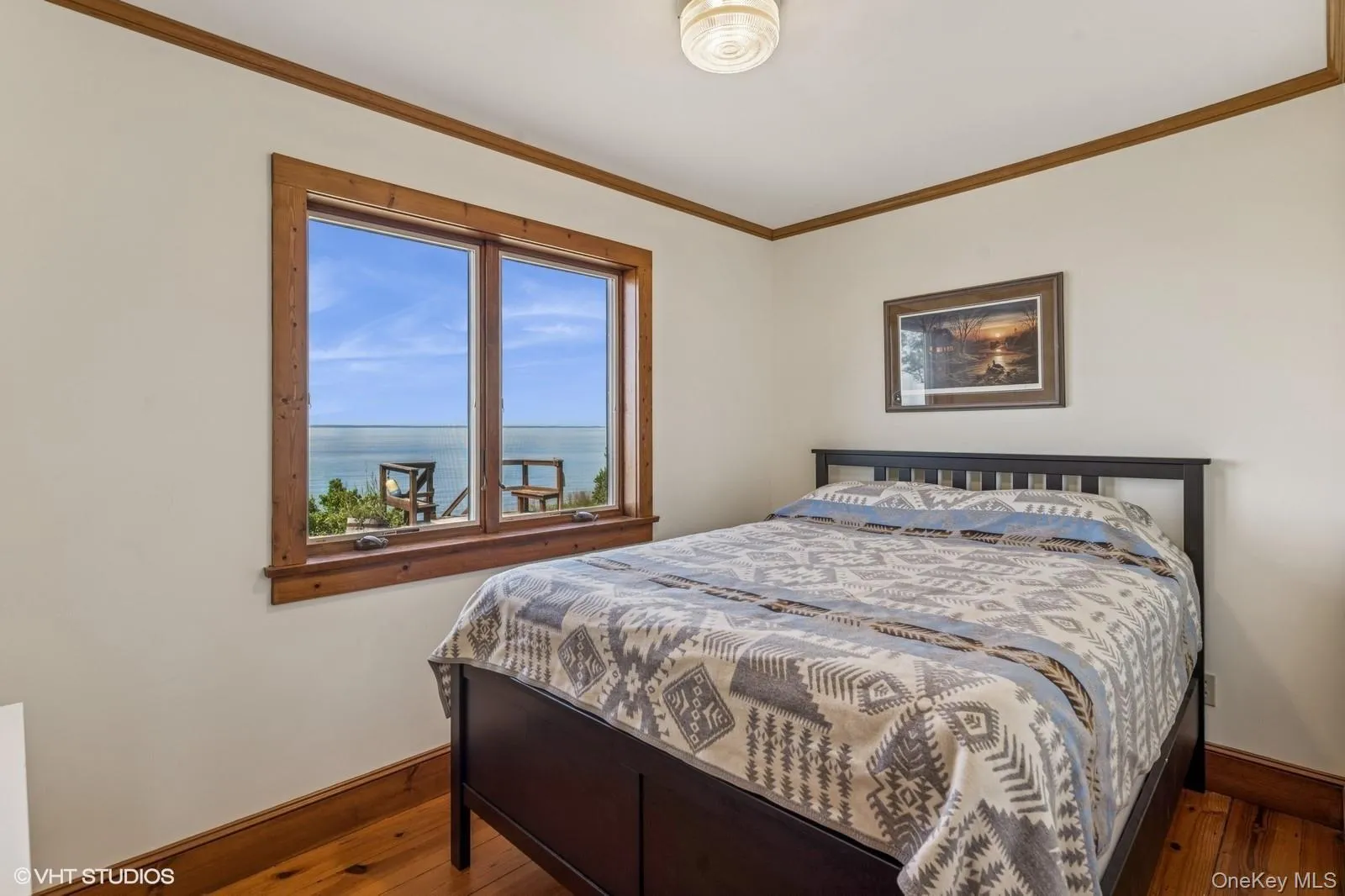 Bedroom with ornamental molding, a water view, and wood-type flooring Bedroom with ornamental molding, a water view, and wood-type flooring