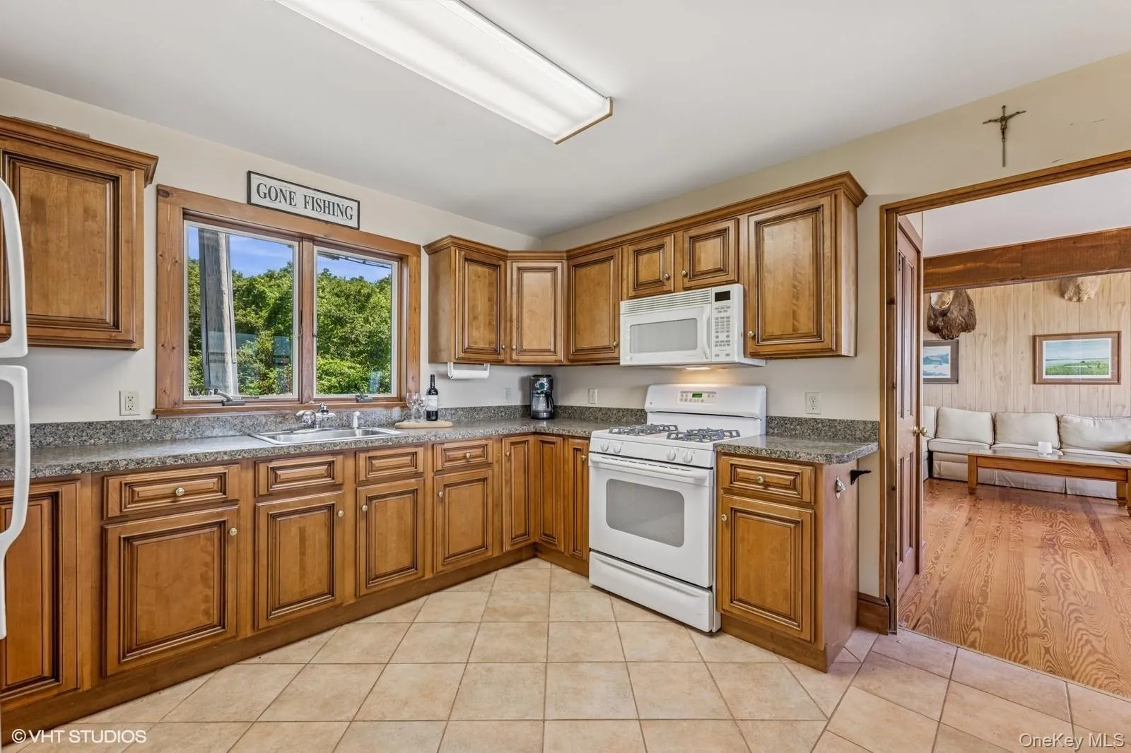 Kitchen with white appliances, brown cabinets, and light tile patterned floors Kitchen with white appliances, brown cabinets, and light tile patterned floors