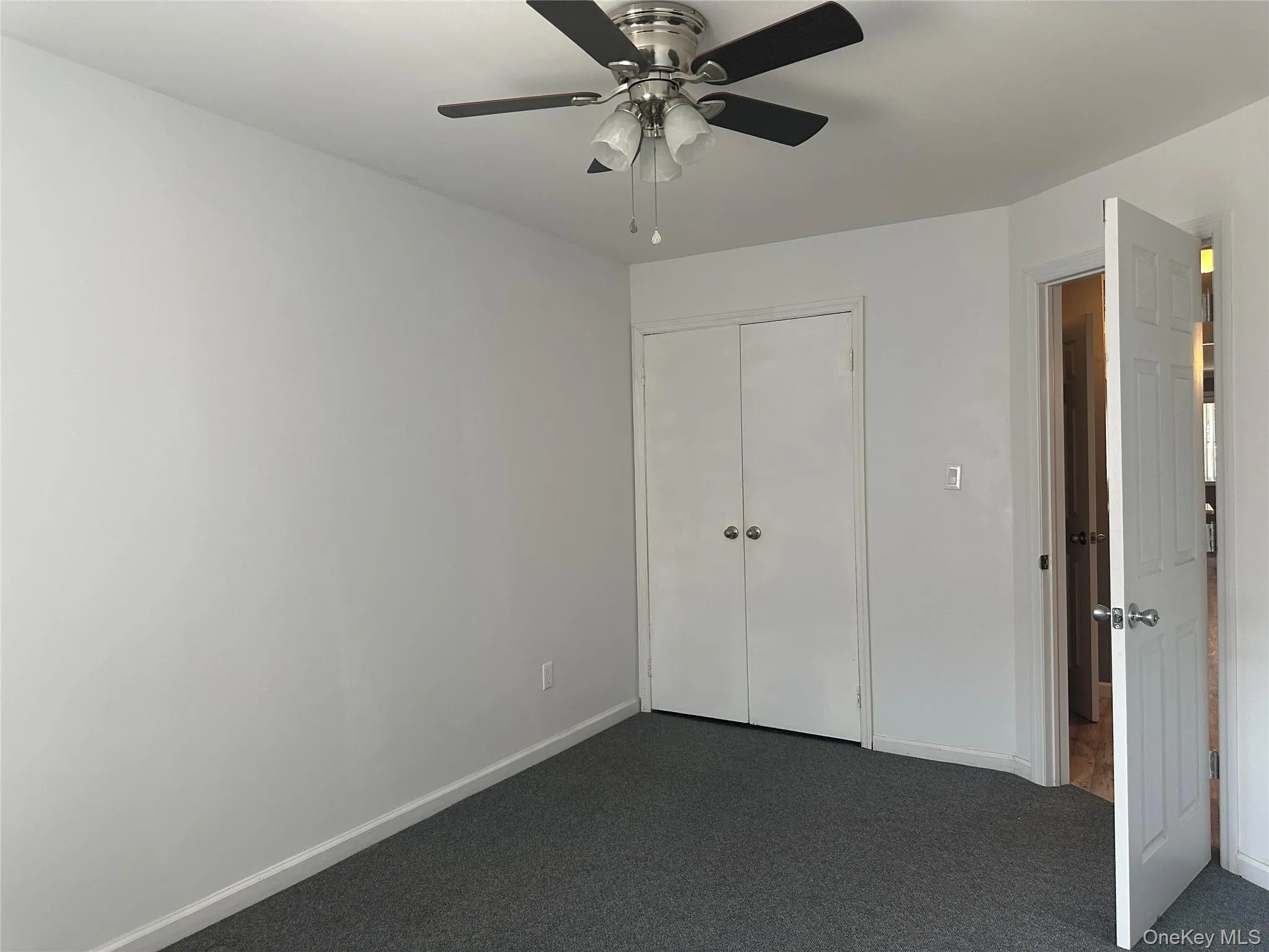 Unfurnished bedroom with carpet flooring, a closet, and ceiling fan Unfurnished bedroom with carpet flooring, a closet, and ceiling fan