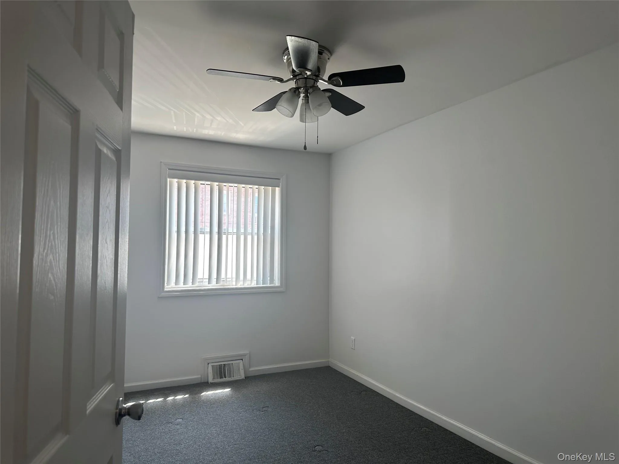 Unfurnished room featuring ceiling fan and dark colored carpet Unfurnished room featuring ceiling fan and dark colored carpet