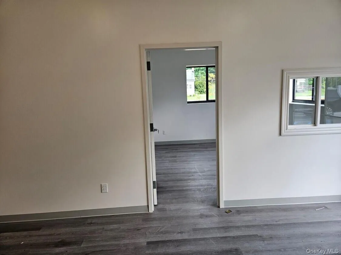 Empty room featuring baseboards and dark wood finished floors Empty room featuring baseboards and dark wood finished floors