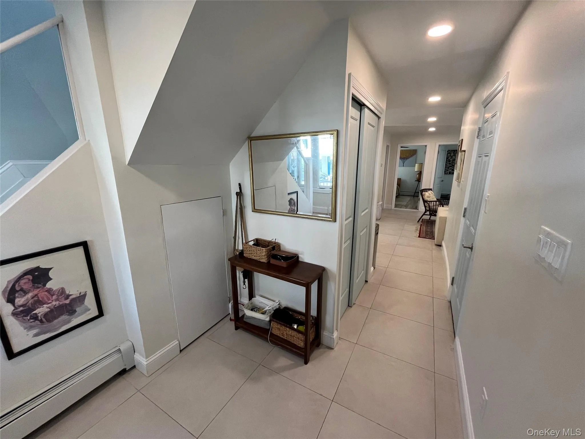 Hallway featuring a baseboard radiator, light tile patterned floors, and recessed lighting Hallway featuring a baseboard radiator, light tile patterned floors, and recessed lighting