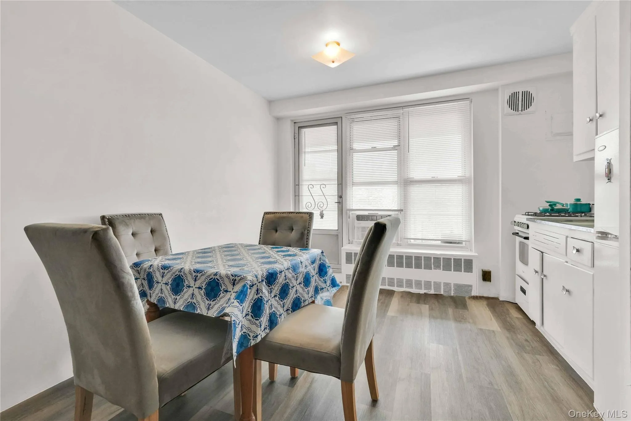 Dining area with light wood-style floors and radiator Dining area with light wood-style floors and radiator