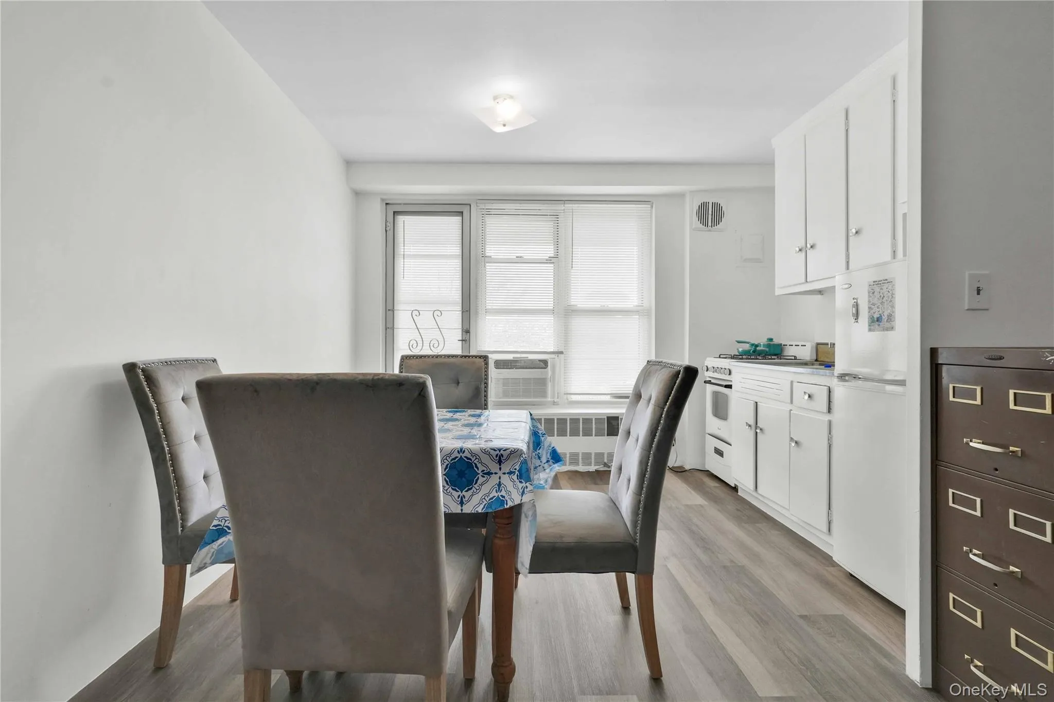 Dining room featuring light wood-style floors and radiator heating unit Dining room featuring light wood-style floors and radiator heating unit