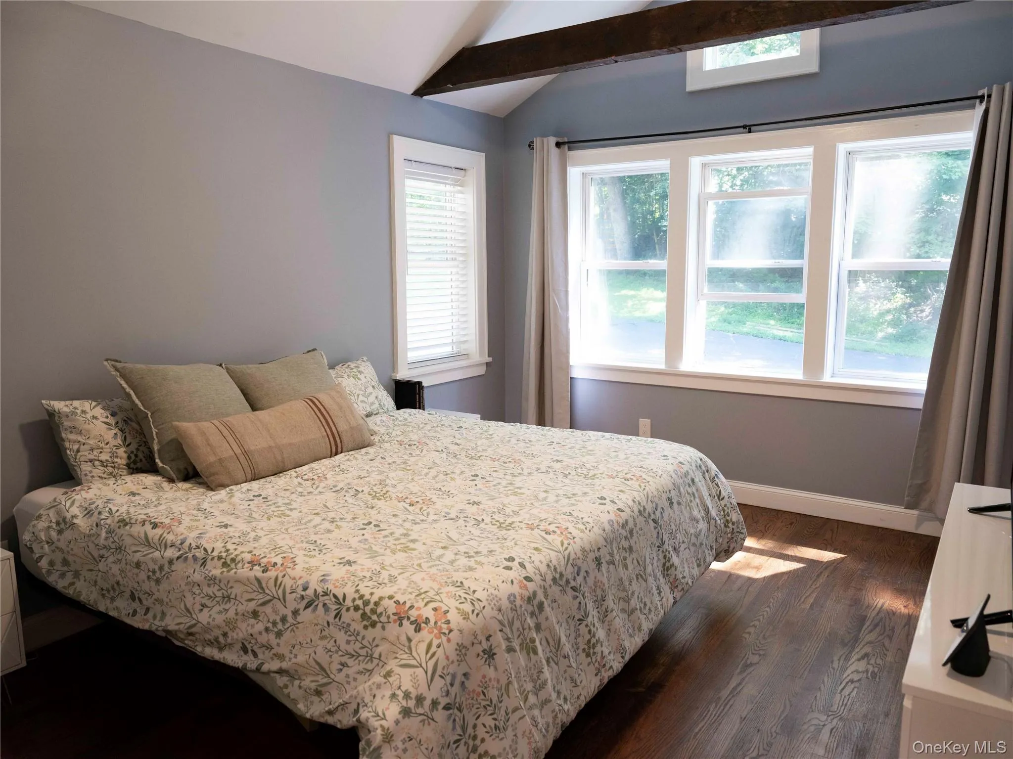Bedroom with dark wood finished floors and baseboards Bedroom with dark wood finished floors and baseboards