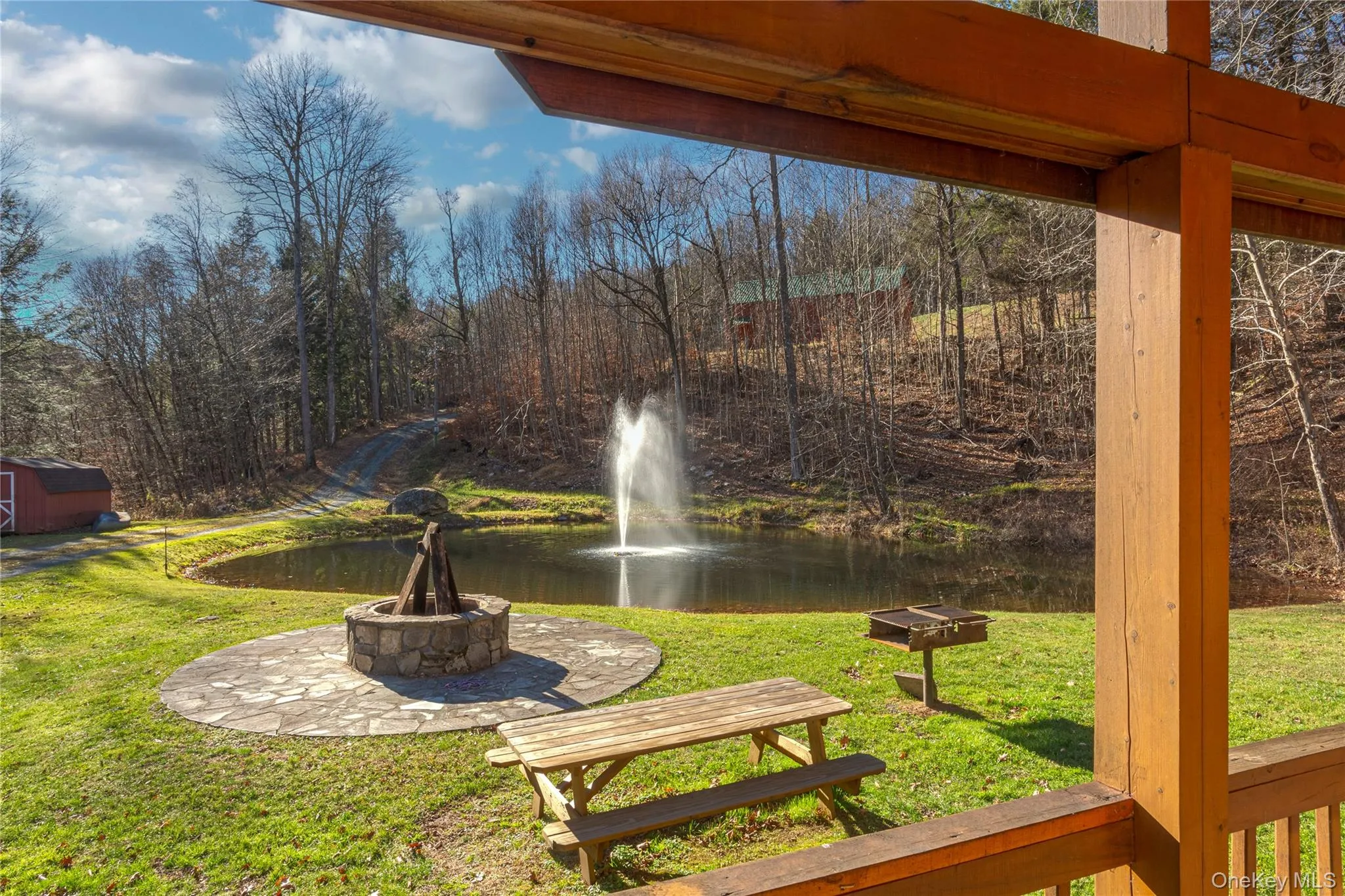 View of green lawn featuring a patio, a water view, and a storage shed View of green lawn featuring a patio, a water view, and a storage shed