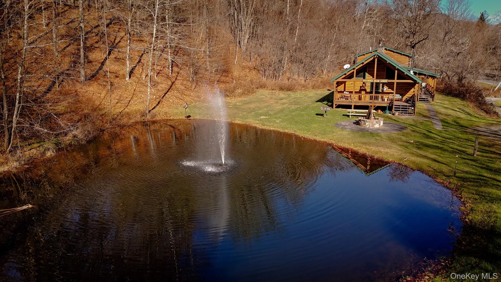 Aerial view of property and surrounding area featuring a nearby body of water and a forest Aerial view of property and surrounding area featuring a nearby body of water and a forest