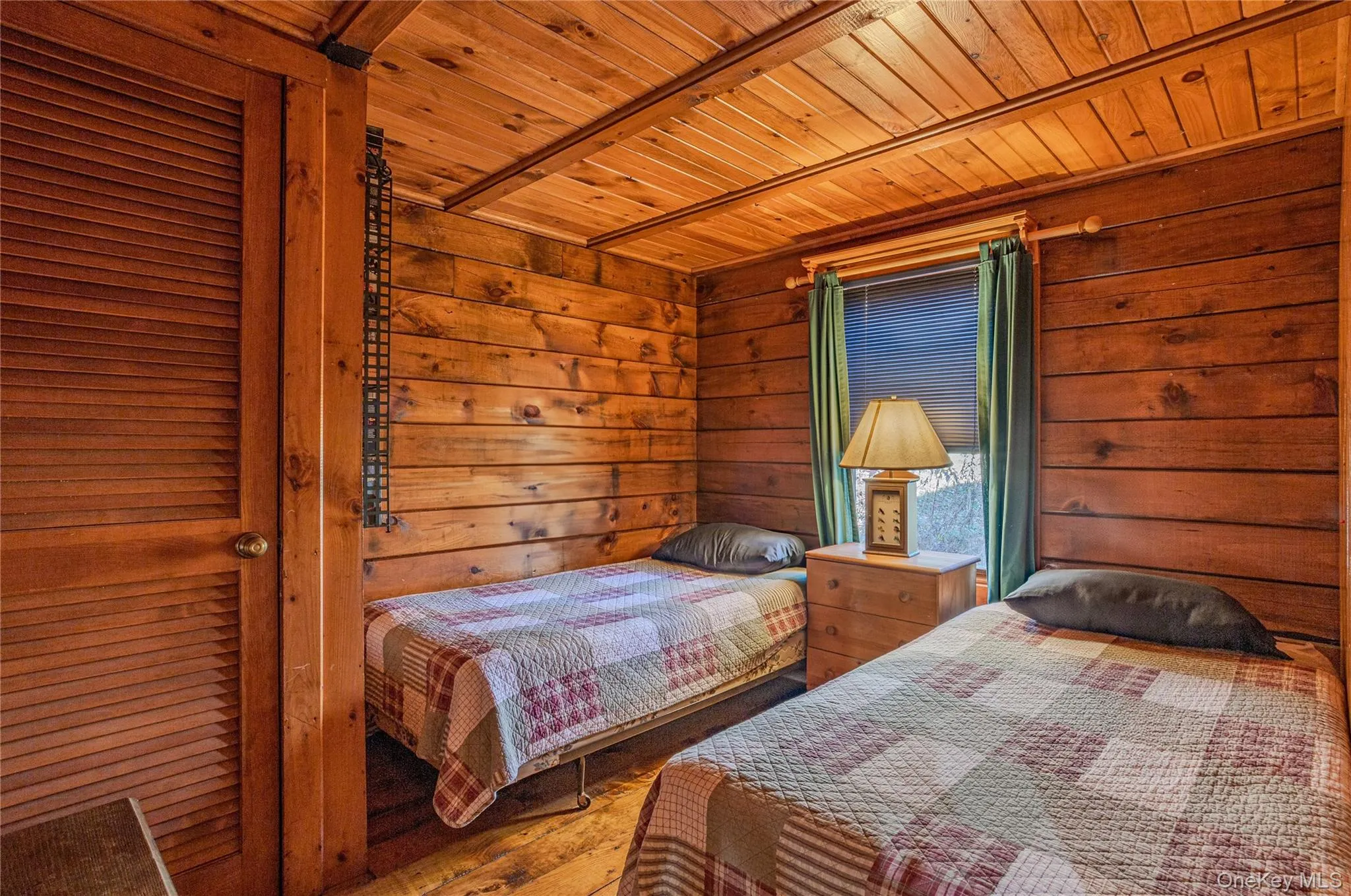 Bedroom featuring wooden ceiling, wood finished floors, and wooden walls Bedroom featuring wooden ceiling, wood finished floors, and wooden walls