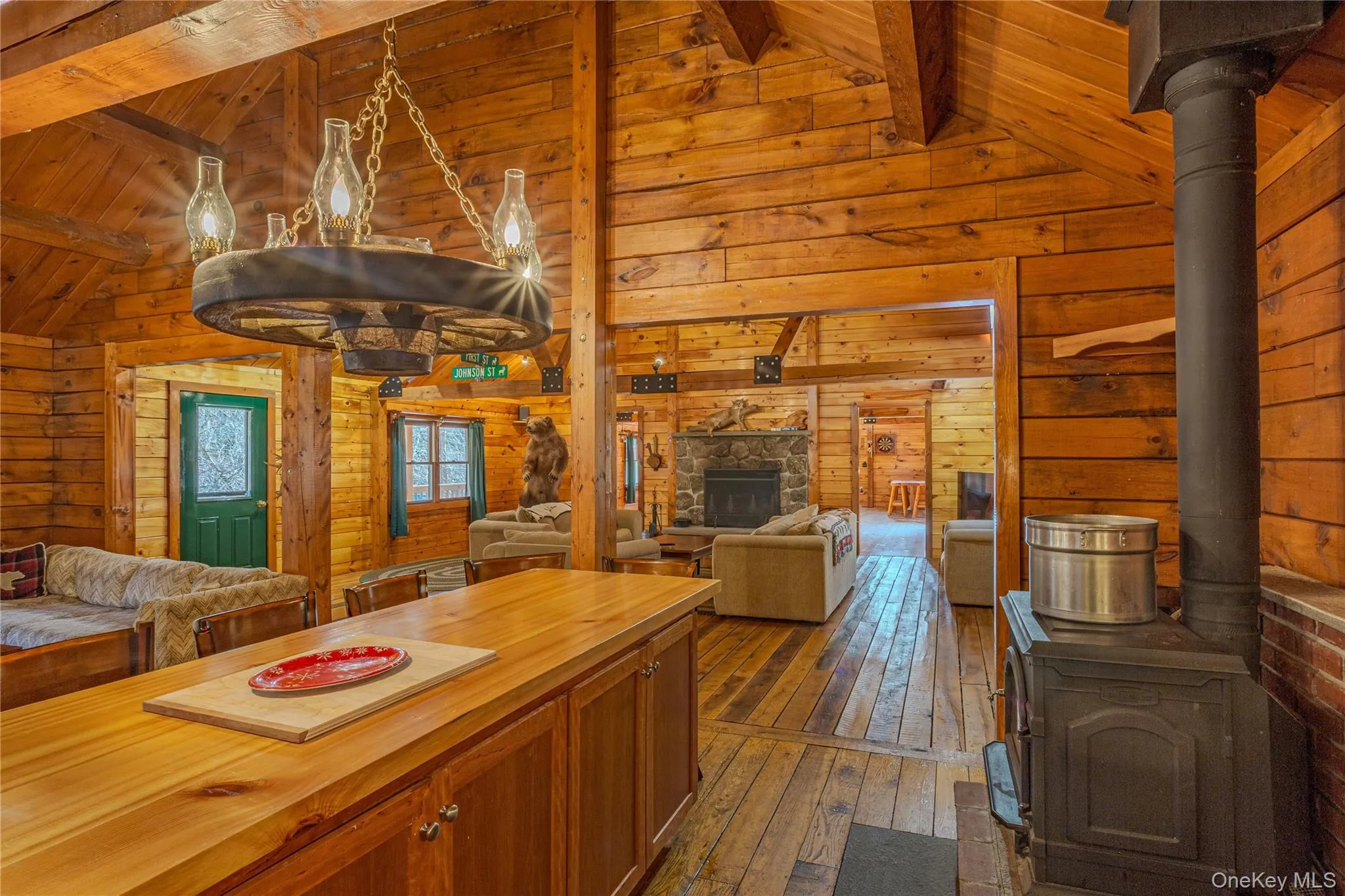 Kitchen with open floor plan, dark wood-style floors, wooden counters, a fireplace, and wooden walls Kitchen with open floor plan, dark wood-style floors, wooden counters, a fireplace, and wooden walls