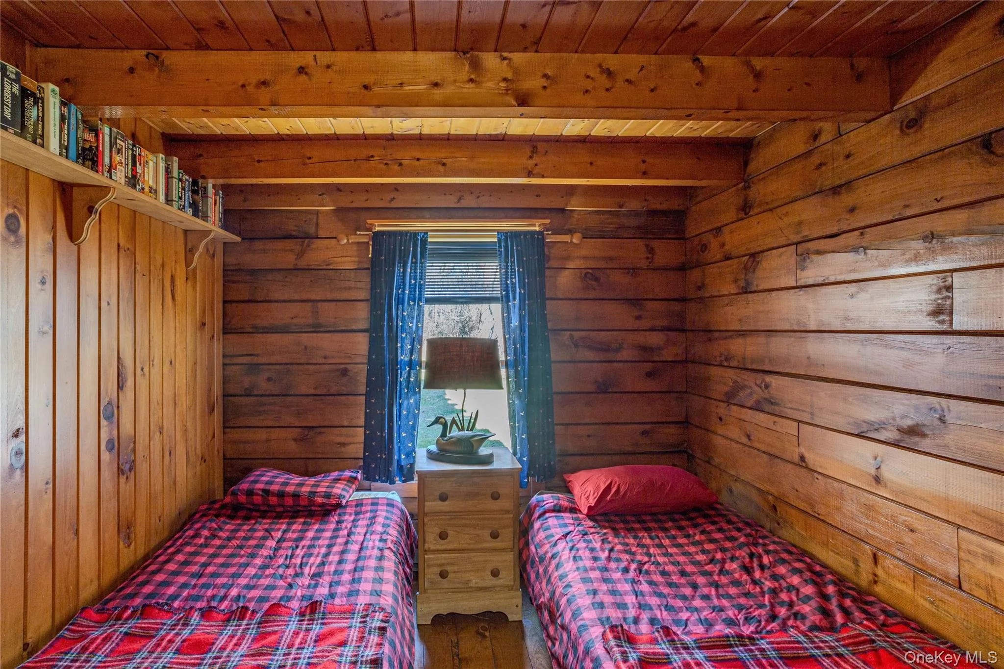 Bedroom featuring wood walls and a wooden ceiling with exposed beams Bedroom featuring wood walls and a wooden ceiling with exposed beams