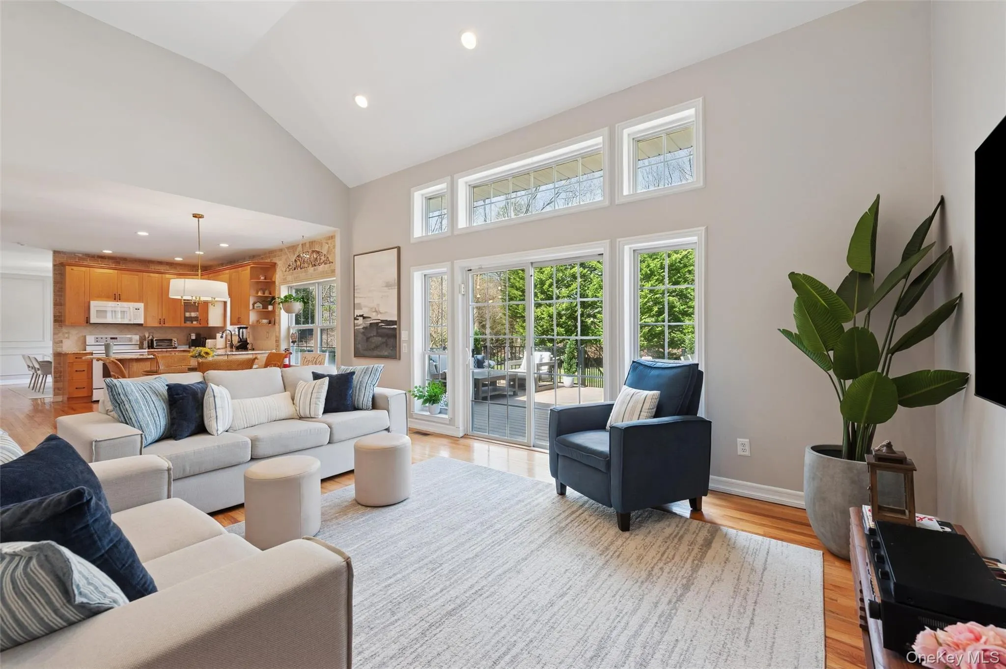 Living room featuring high vaulted ceiling, recessed lighting, and light wood finished floors Living room featuring high vaulted ceiling, recessed lighting, and light wood finished floors