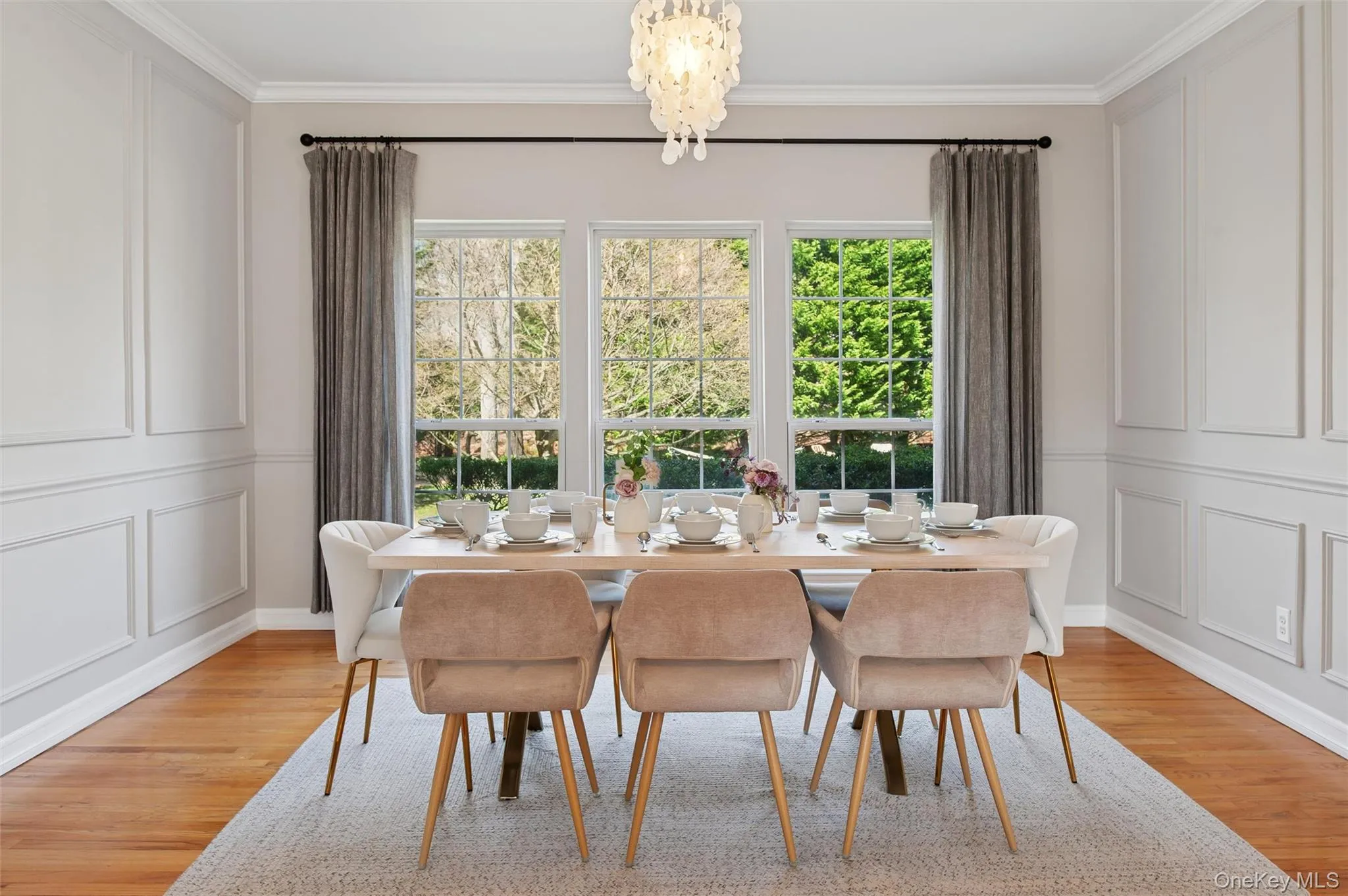 Dining area featuring a decorative wall, light wood-style flooring, and crown molding Dining area featuring a decorative wall, light wood-style flooring, and crown molding