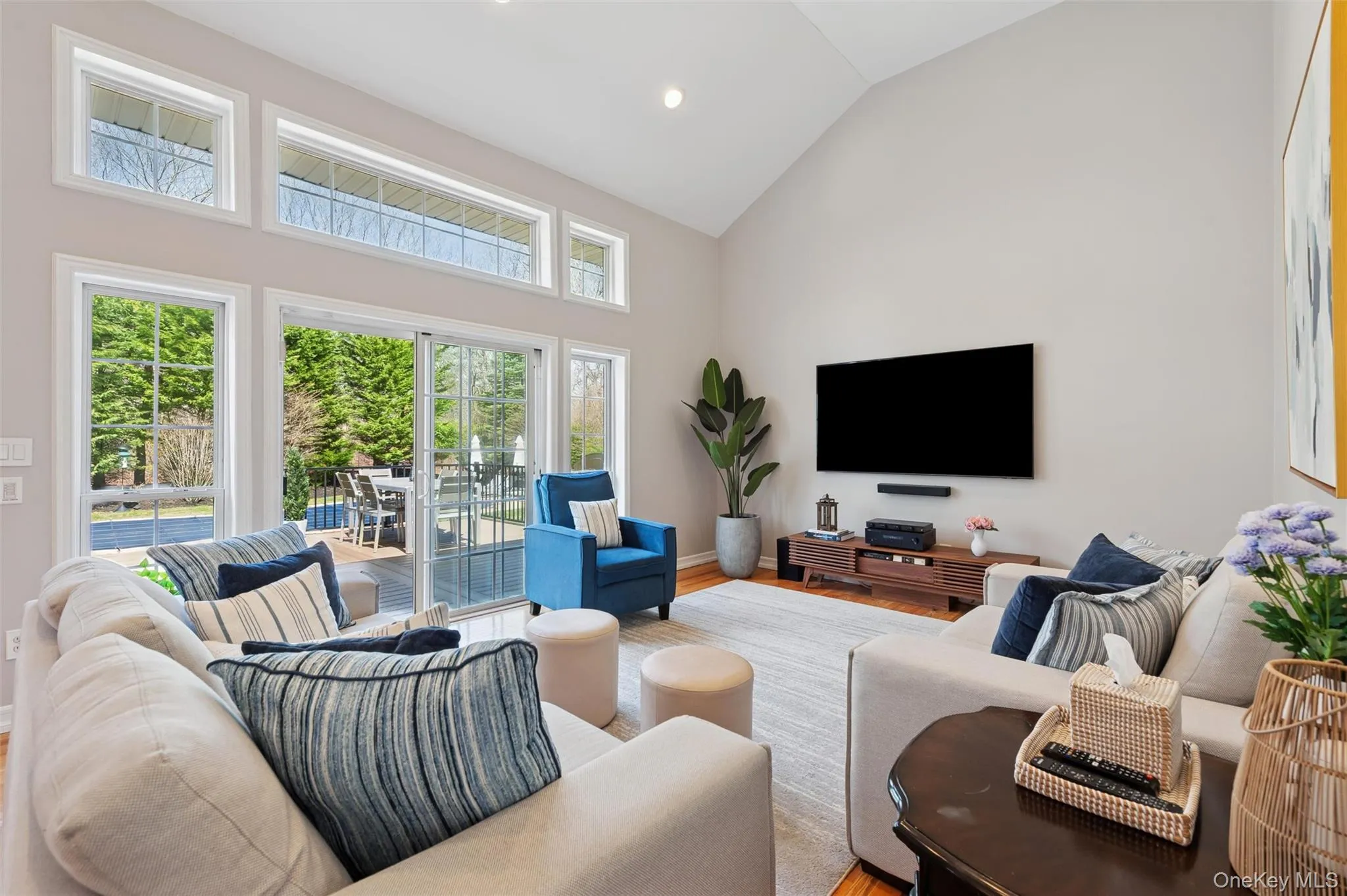 Living area with high vaulted ceiling, recessed lighting, baseboards, and wood finished floors Living area with high vaulted ceiling, recessed lighting, baseboards, and wood finished floors