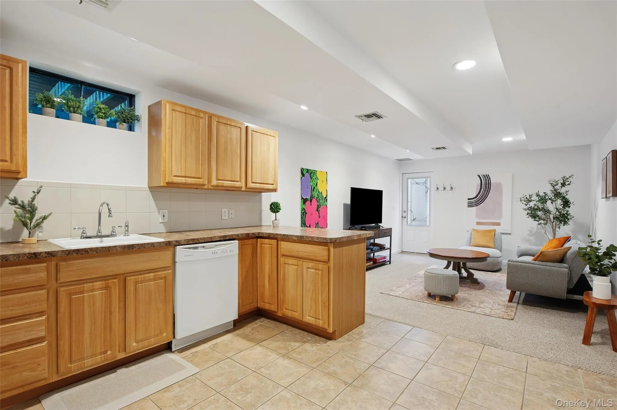 Kitchen with light tile patterned floors, visible vents, dishwasher, a sink, and open floor plan Kitchen with light tile patterned floors, visible vents, dishwasher, a sink, and open floor plan
