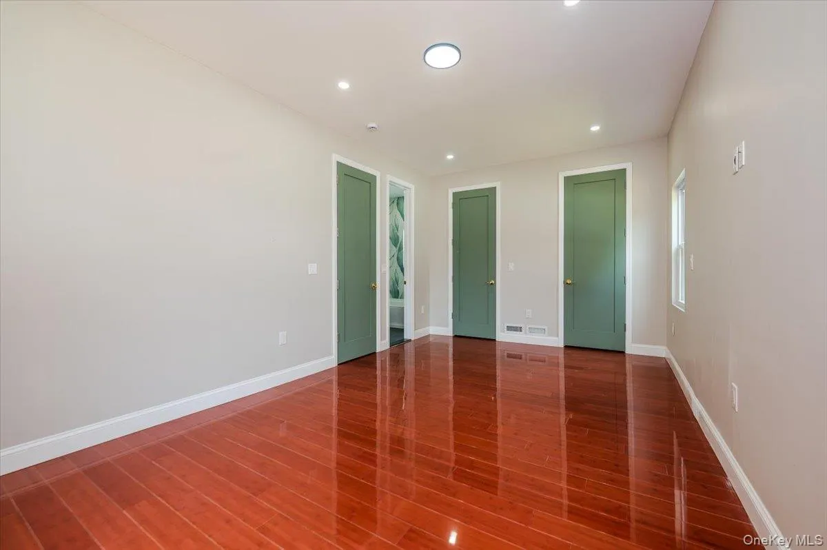 Unfurnished room with recessed lighting and dark wood-style floors Unfurnished room with recessed lighting and dark wood-style floors