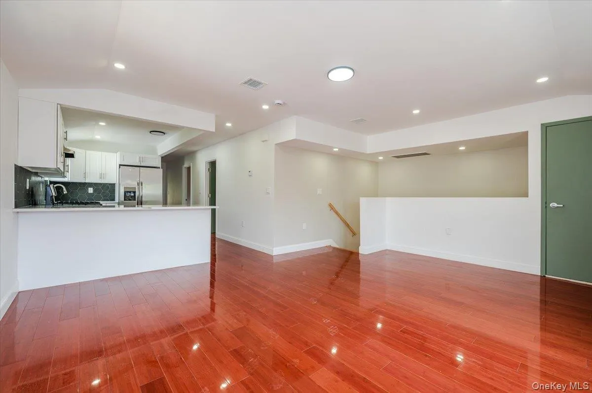 Unfurnished living room with recessed lighting, light wood-type flooring, and vaulted ceiling Unfurnished living room with recessed lighting, light wood-type flooring, and vaulted ceiling