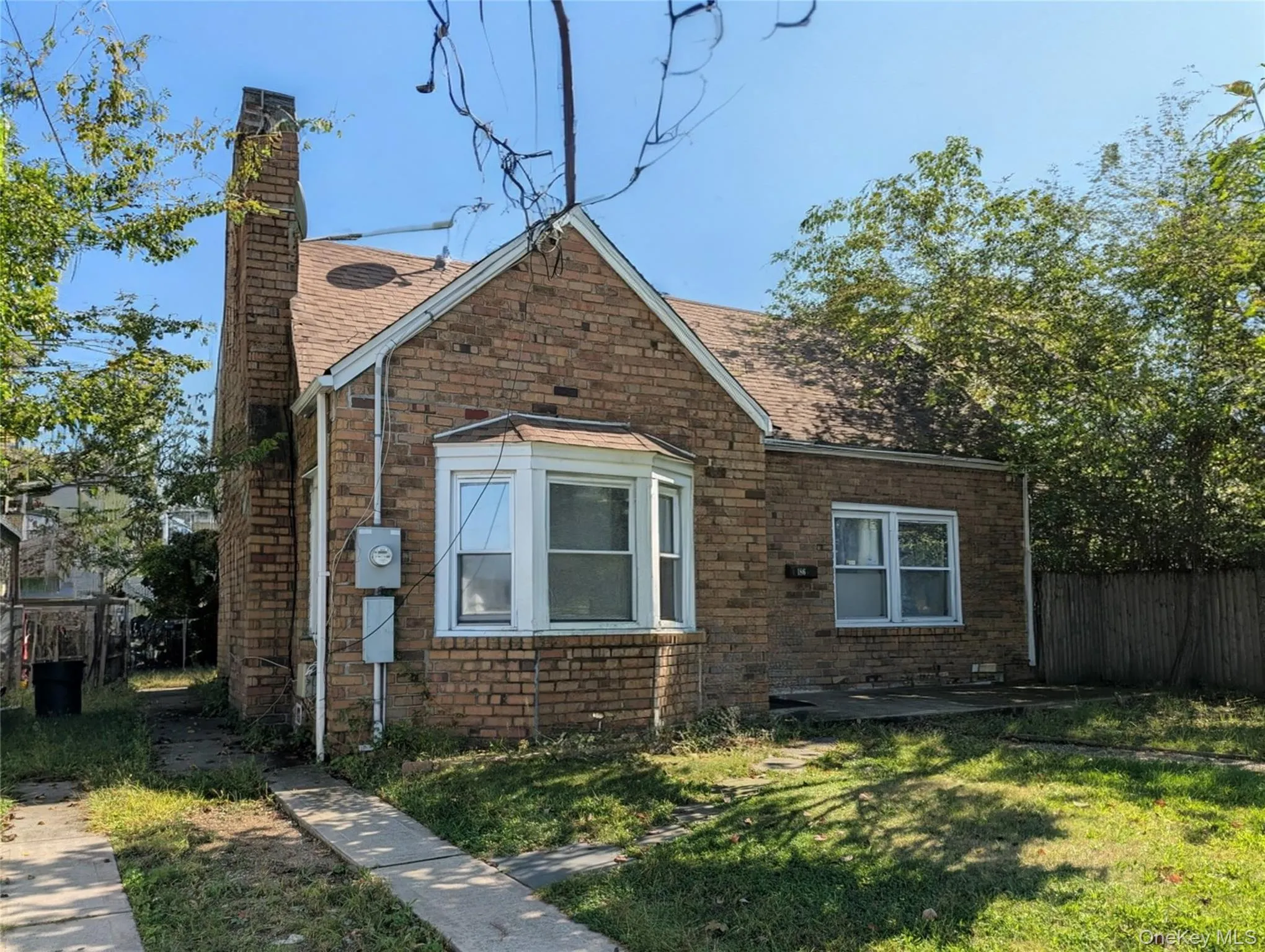 View of home's exterior with a chimney, roof with shingles, and brick siding View of home's exterior with a chimney, roof with shingles, and brick siding