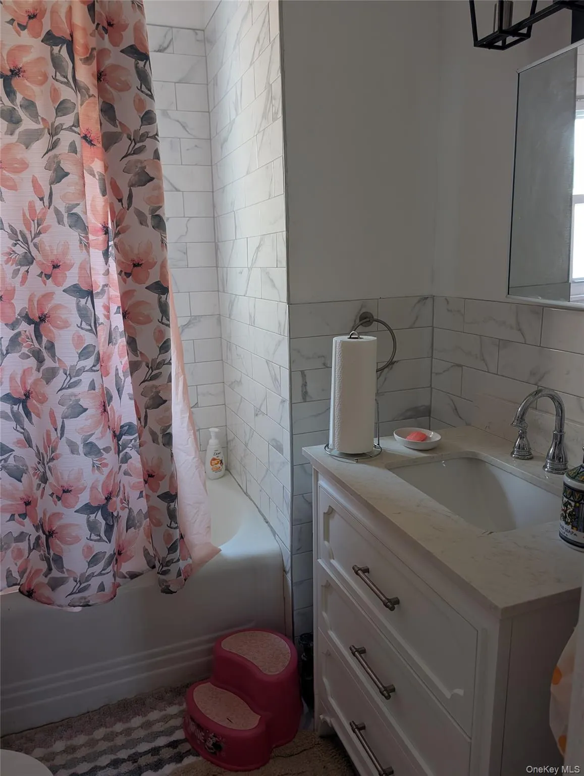 Full bath featuring vanity, shower / bath combination with curtain, and tile walls Full bath featuring vanity, shower / bath combination with curtain, and tile walls