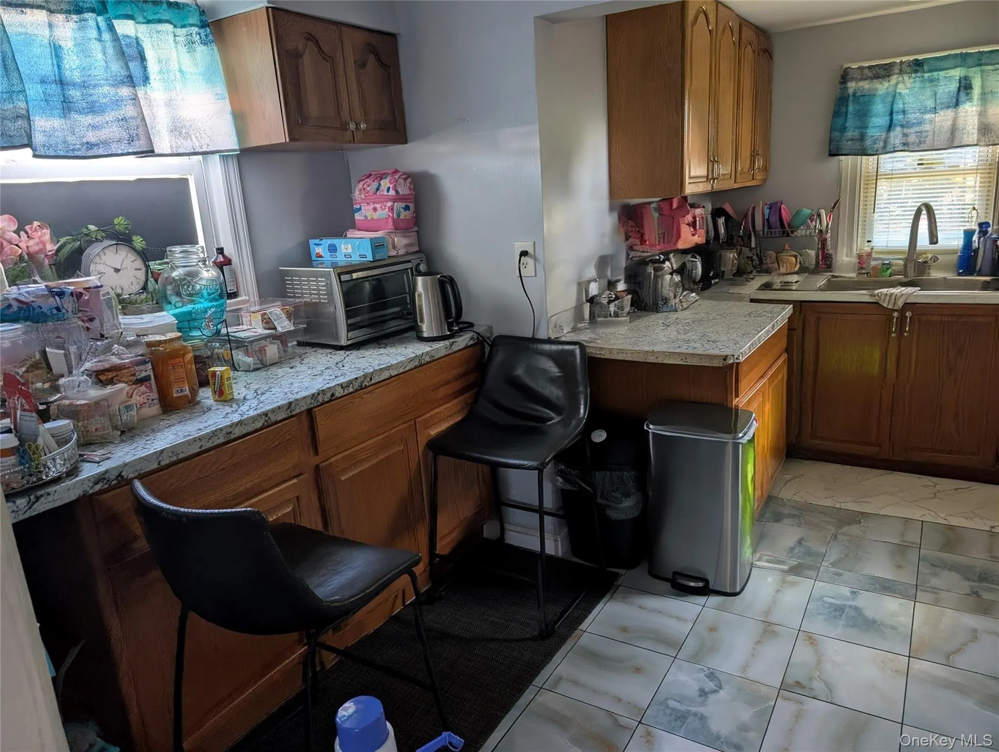 Kitchen with brown cabinets, light countertops, and light tile patterned flooring Kitchen with brown cabinets, light countertops, and light tile patterned flooring