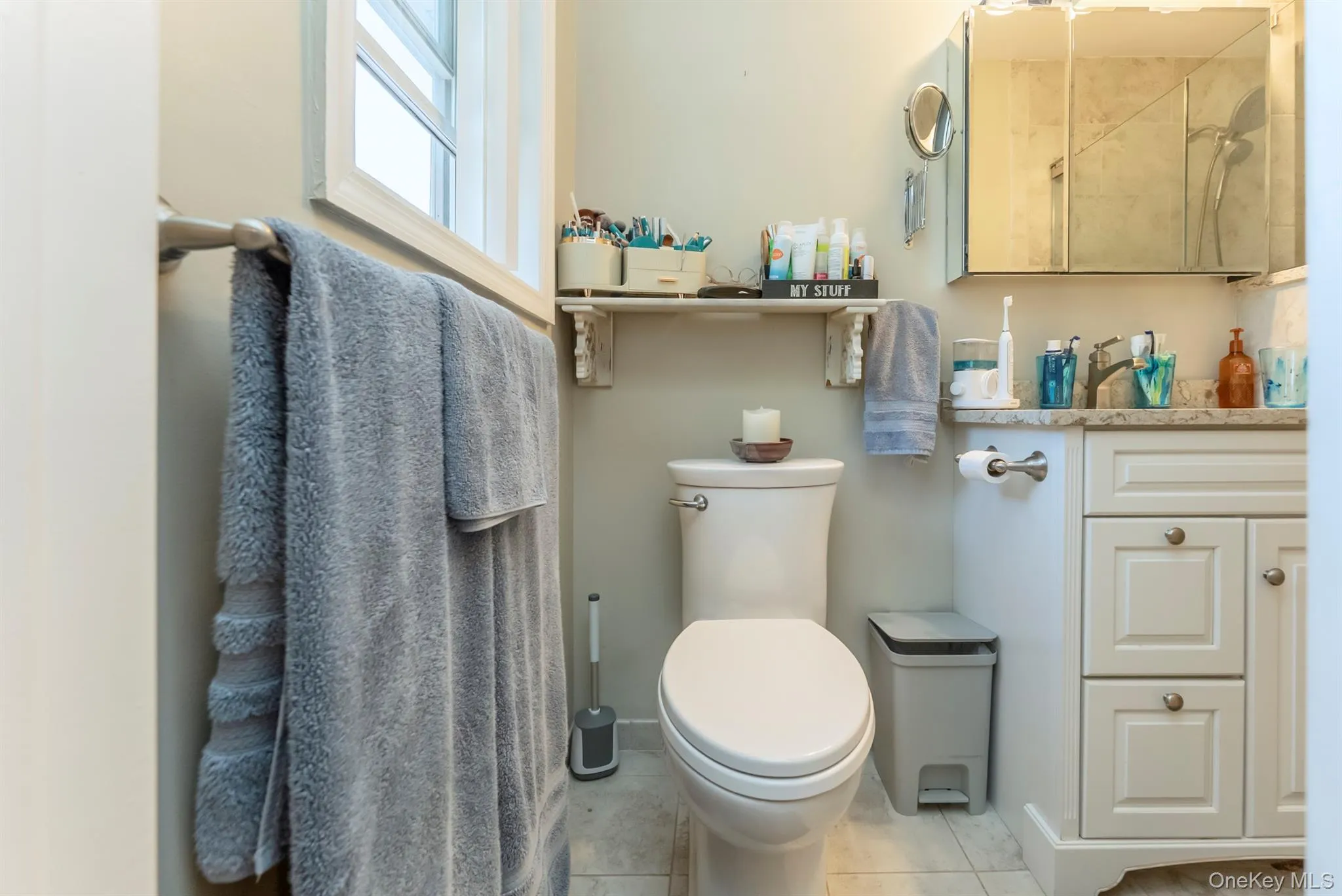Bathroom featuring vanity, light tile patterned floors, and a tile shower Bathroom featuring vanity, light tile patterned floors, and a tile shower