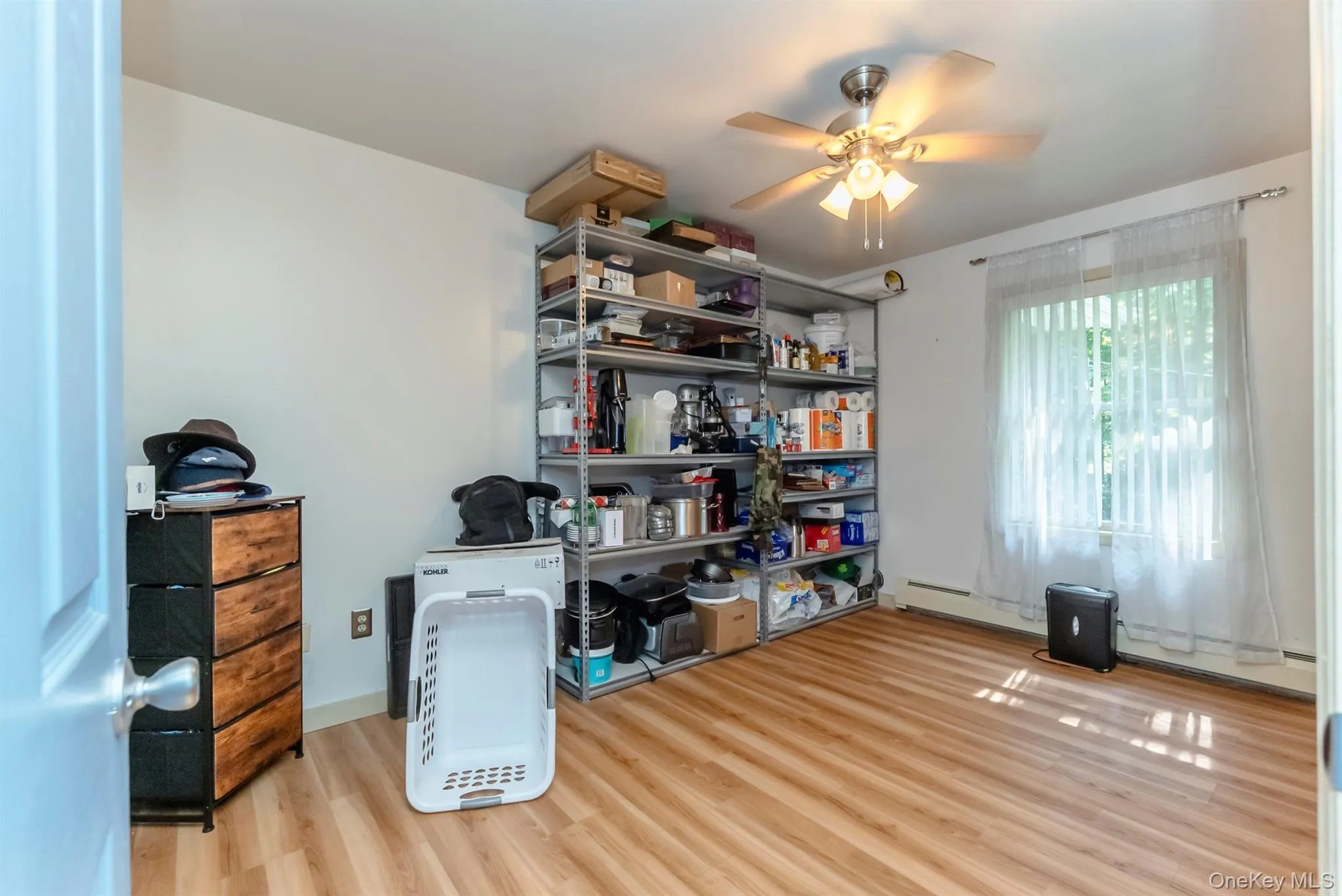 Storage area with ceiling fan and a baseboard heating unit Storage area with ceiling fan and a baseboard heating unit