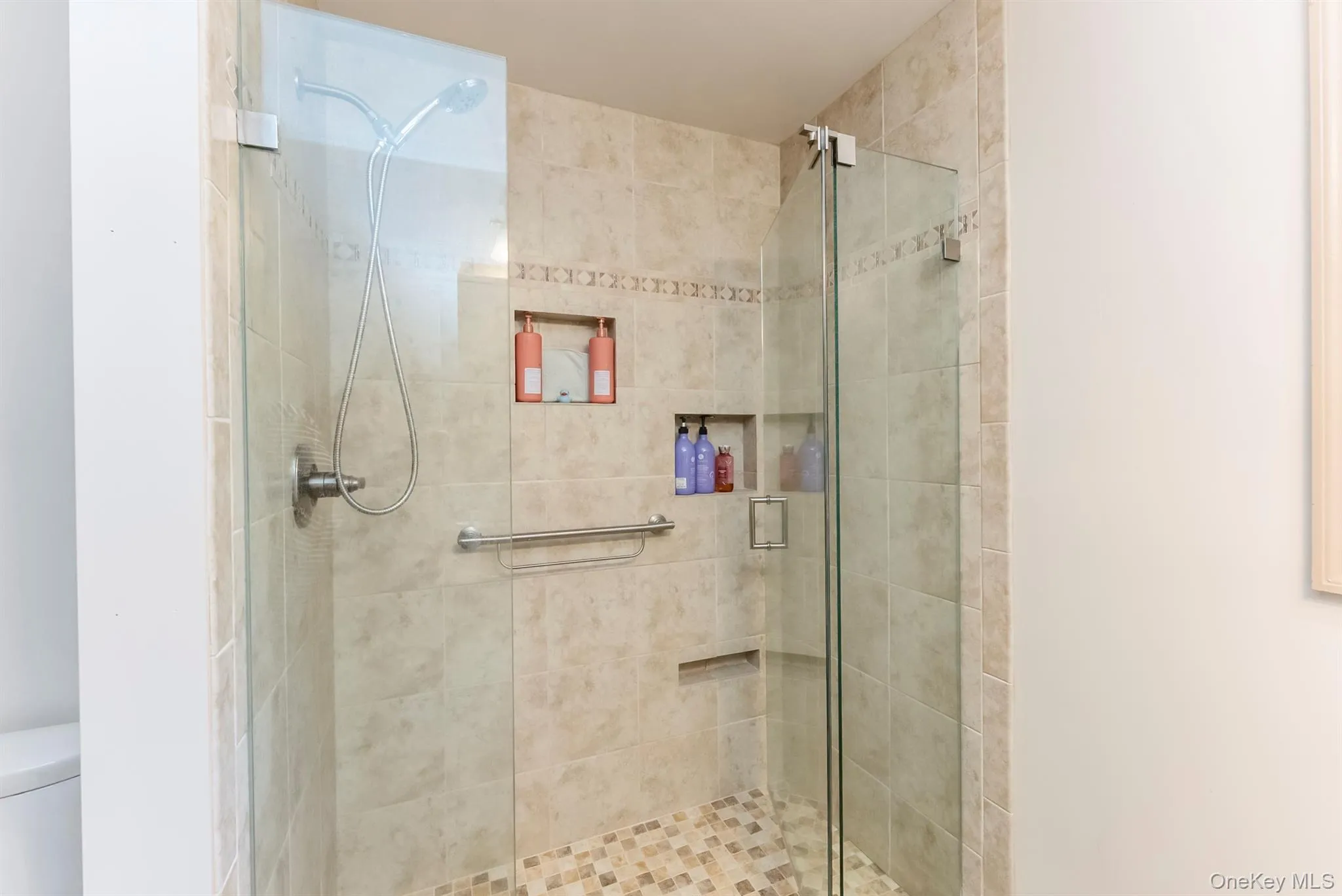 Full bath featuring a stall shower and toilet Full bath featuring a stall shower and toilet