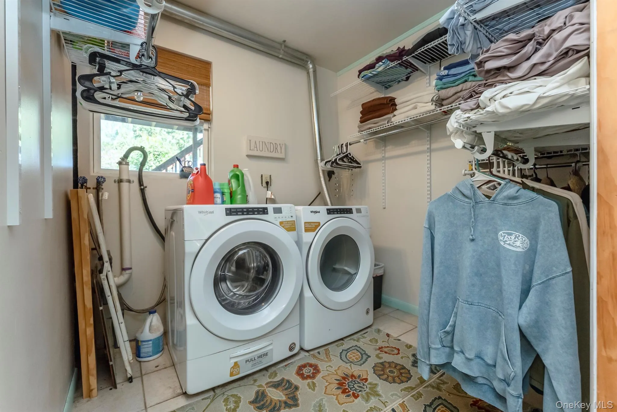 Washroom with light tile patterned floors and independent washer and dryer Washroom with light tile patterned floors and independent washer and dryer