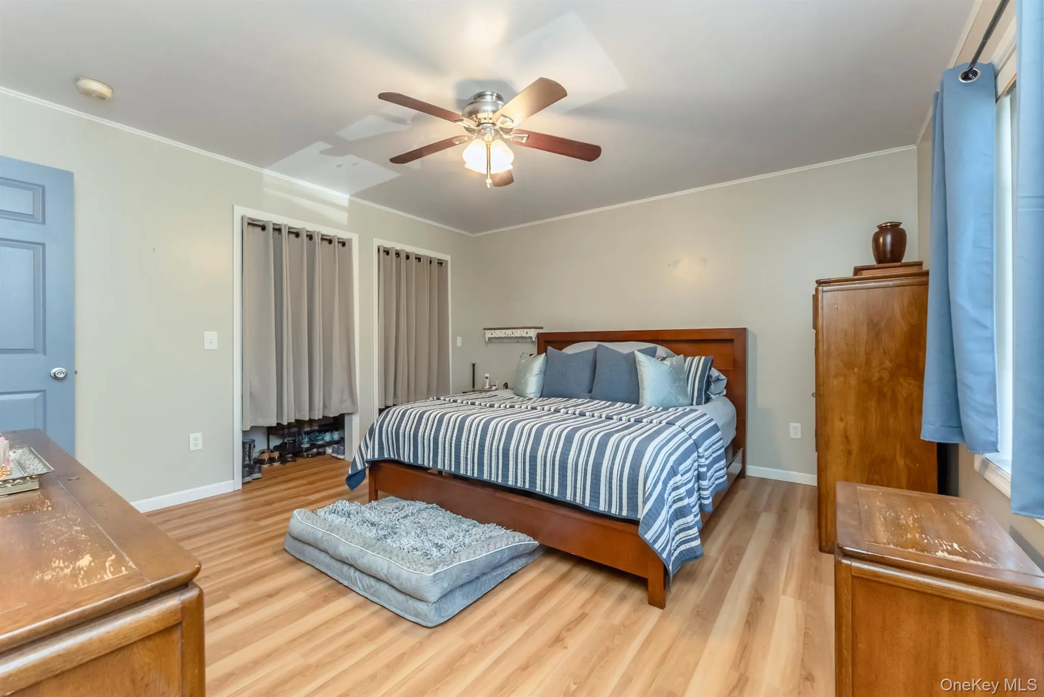 Bedroom with crown molding, light wood finished floors, and ceiling fan Bedroom with crown molding, light wood finished floors, and ceiling fan