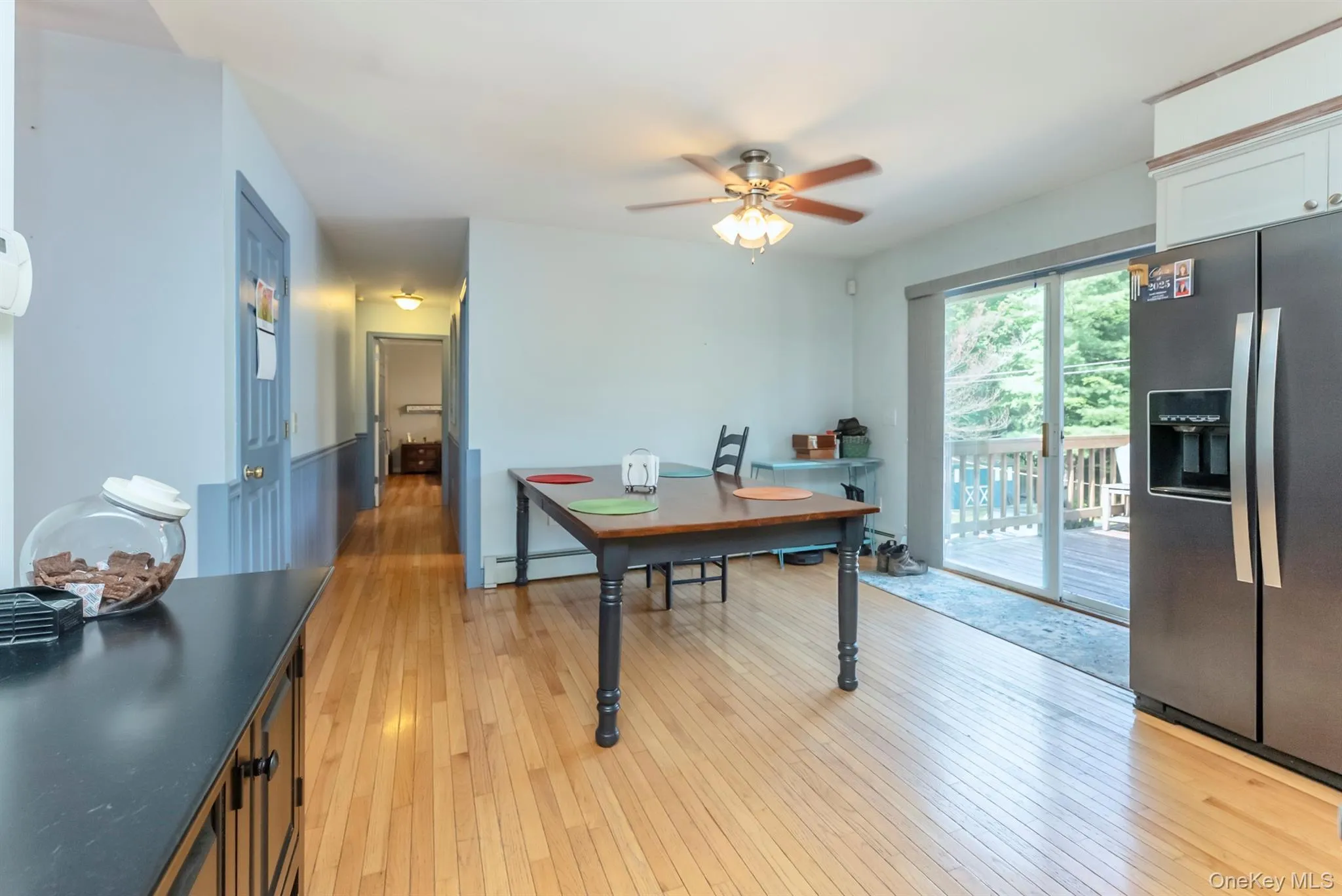 Dining area featuring light wood-style floors, a ceiling fan, and a baseboard heating unit Dining area featuring light wood-style floors, a ceiling fan, and a baseboard heating unit