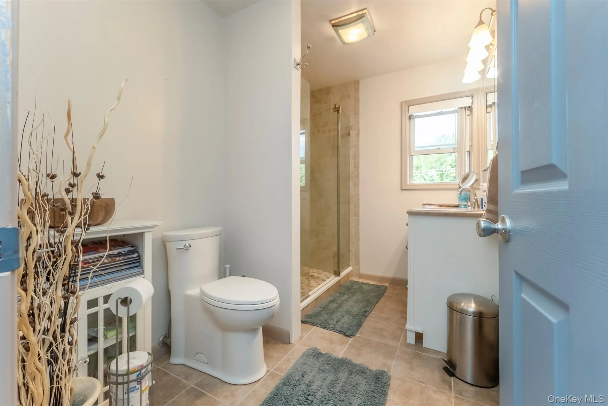 Bathroom with a stall shower and light tile patterned floors Bathroom with a stall shower and light tile patterned floors