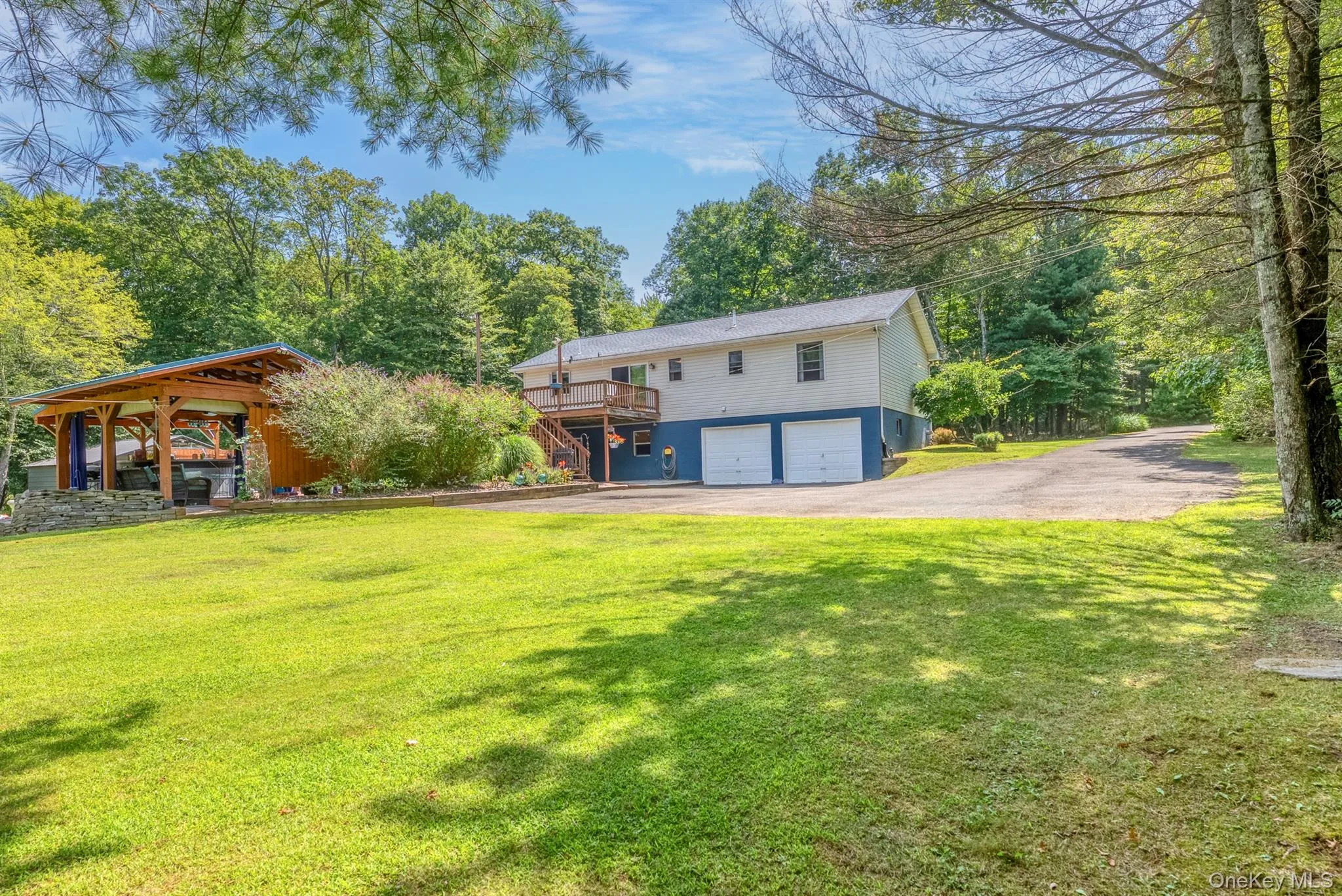 Back of property with an attached garage, a yard, and asphalt driveway Back of property with an attached garage, a yard, and asphalt driveway