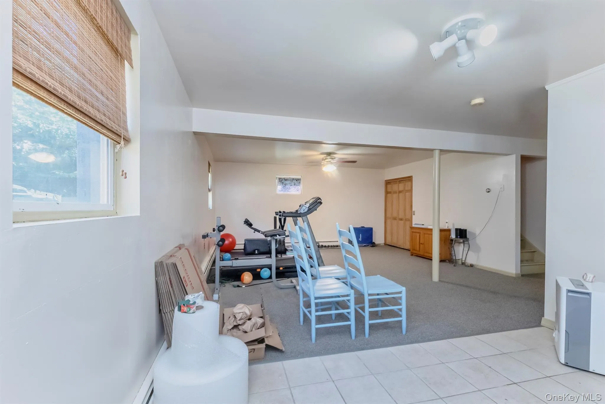 Exercise room featuring light colored carpet, light tile patterned floors, and ceiling fan Exercise room featuring light colored carpet, light tile patterned floors, and ceiling fan