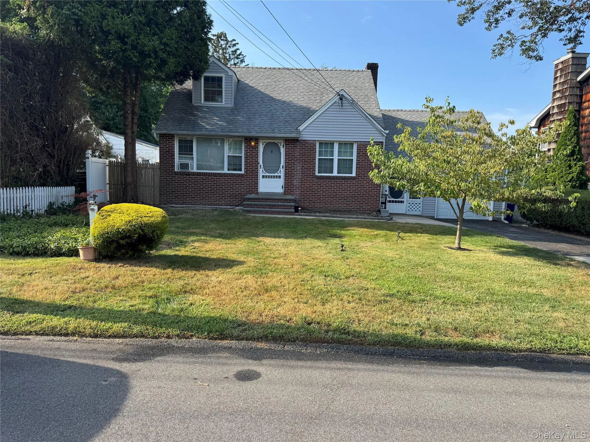 New england style home featuring brick siding and roof with shingles New england style home featuring brick siding and roof with shingles