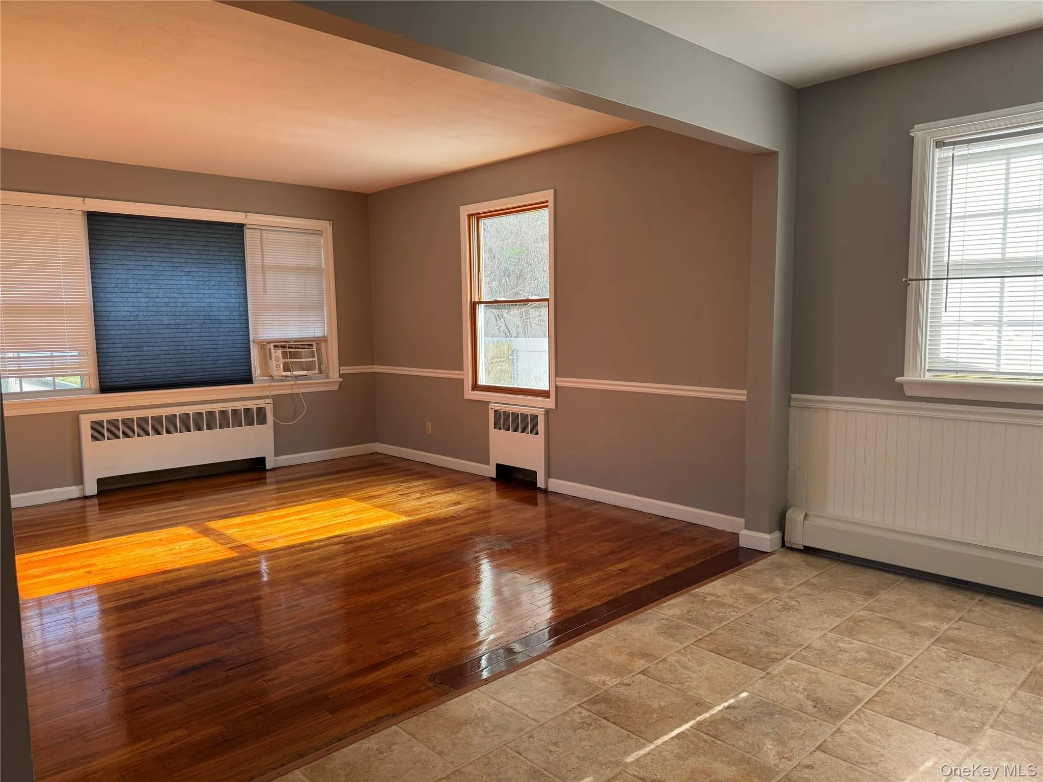 Unfurnished room featuring radiator and light wood-style flooring Unfurnished room featuring radiator and light wood-style flooring
