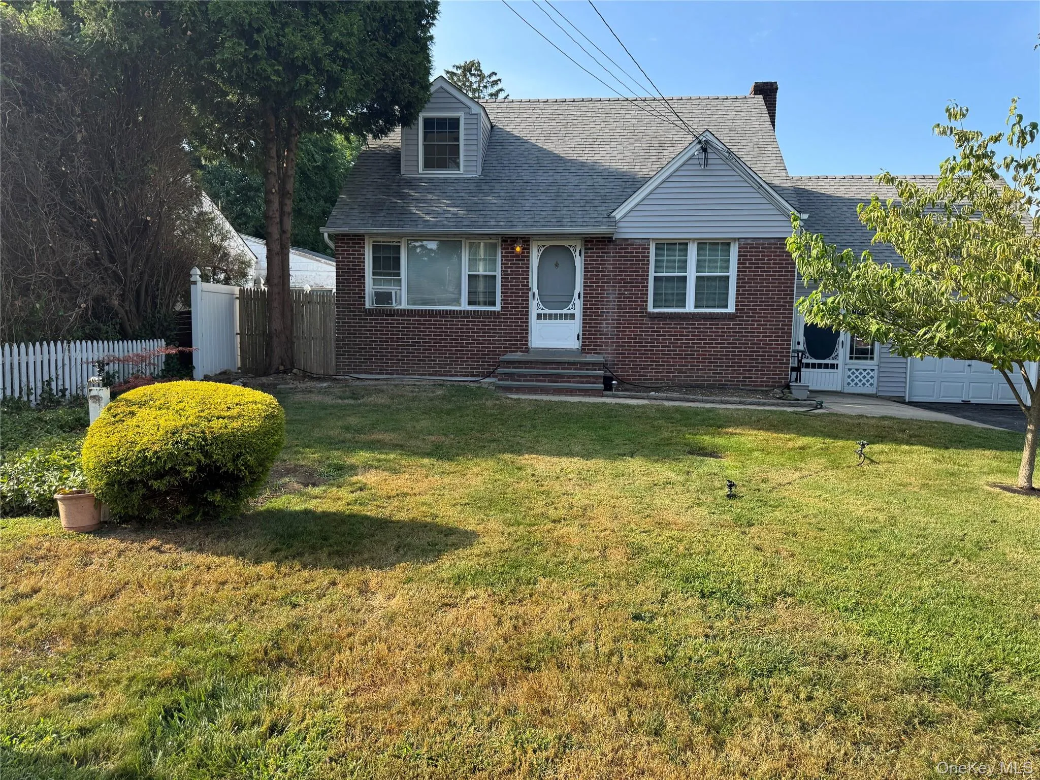 View of front of home with brick siding, roof with shingles, and an attached garage View of front of home with brick siding, roof with shingles, and an attached garage