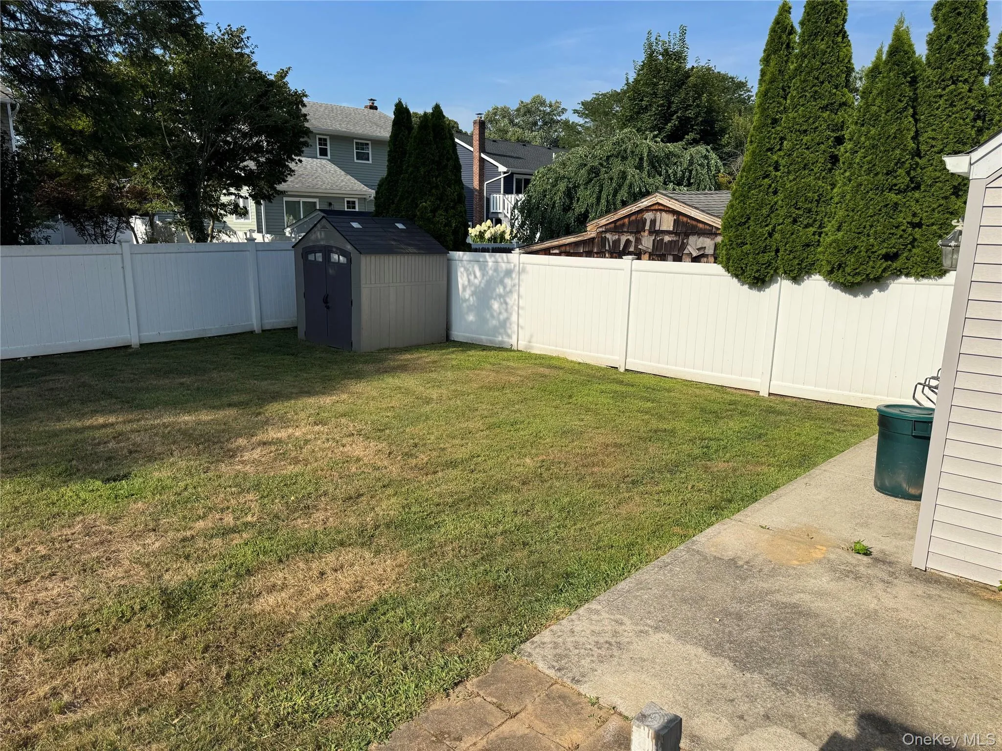 Fenced backyard featuring a storage shed and a residential view Fenced backyard featuring a storage shed and a residential view