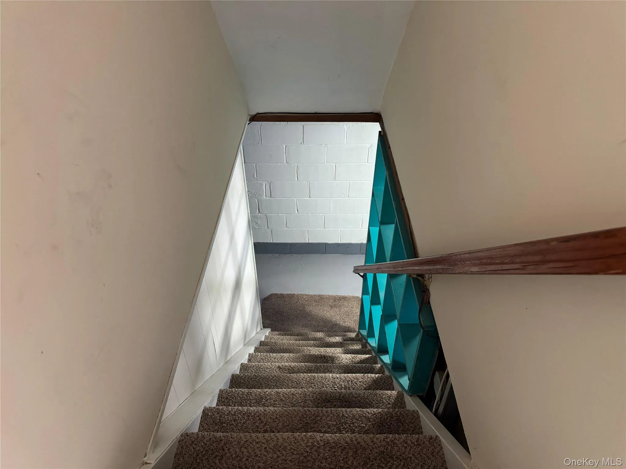 Staircase featuring concrete floors and concrete block wall Staircase featuring concrete floors and concrete block wall