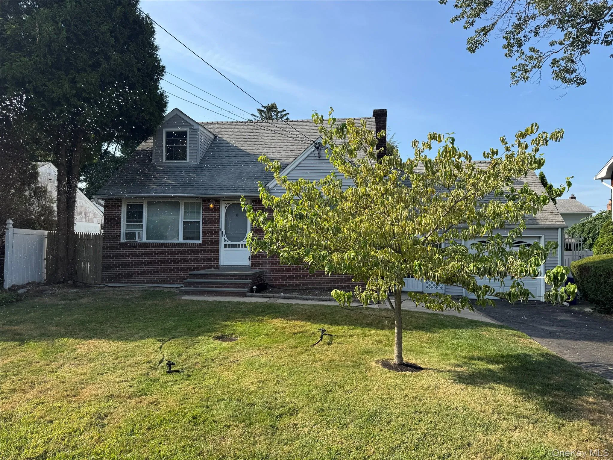 View of front facade with brick siding and a shingled roof View of front facade with brick siding and a shingled roof