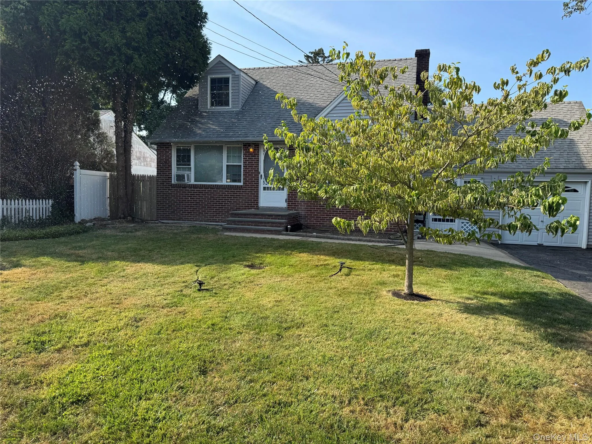 View of front of house with brick siding, roof with shingles, a garage, and driveway View of front of house with brick siding, roof with shingles, a garage, and driveway