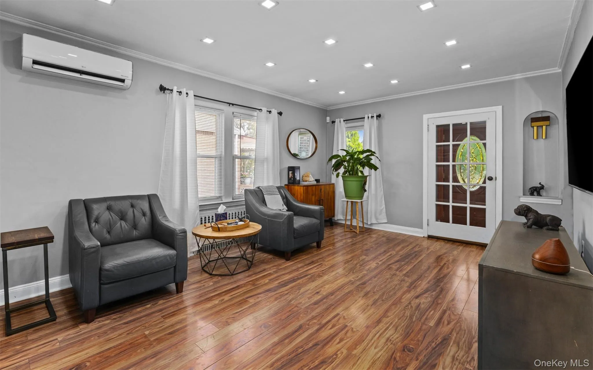 Sitting room featuring wood finished floors, crown molding, an AC wall unit, and recessed lighting Sitting room featuring wood finished floors, crown molding, an AC wall unit, and recessed lighting