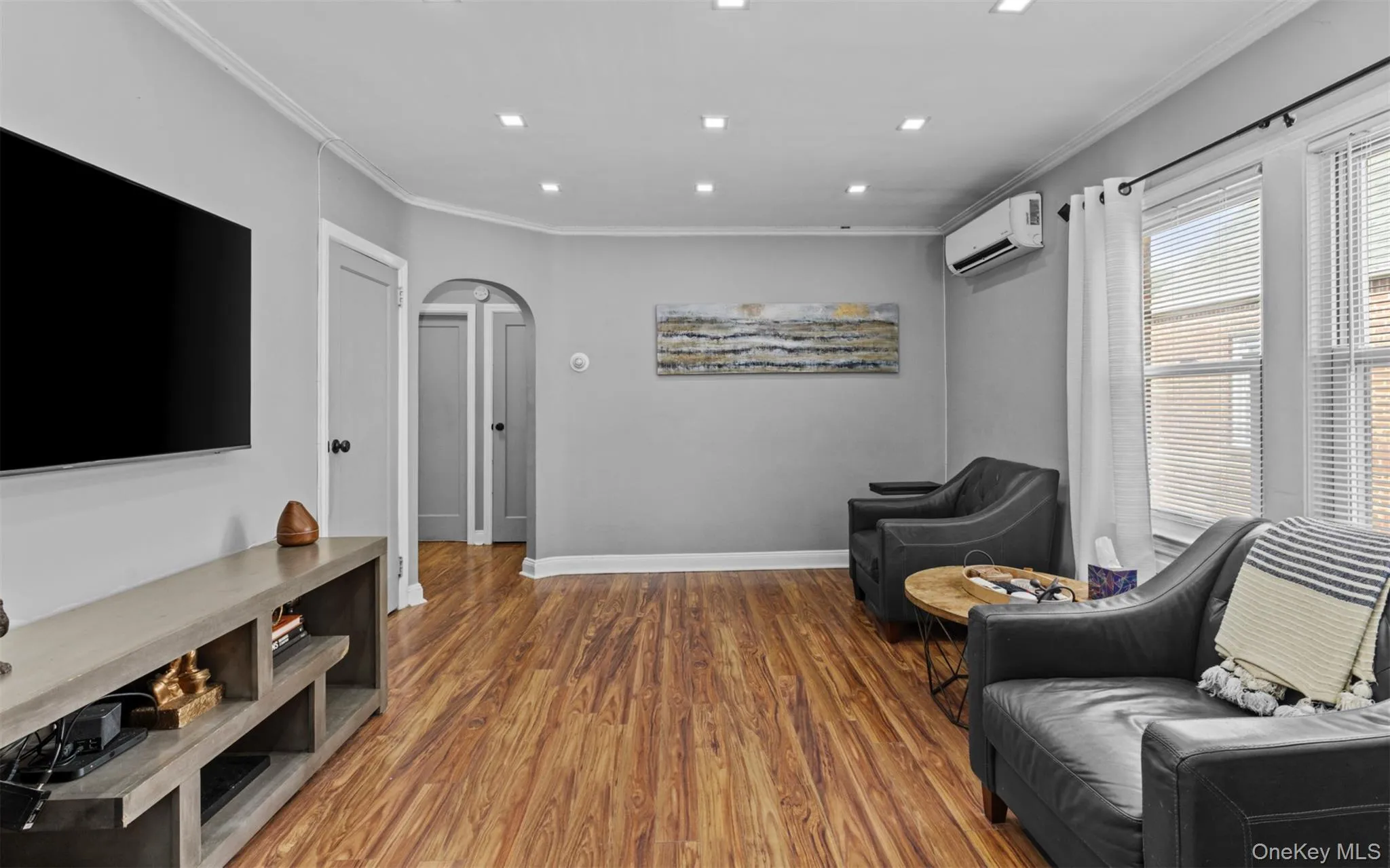 Living area with arched walkways, crown molding, wood finished floors, and recessed lighting Living area with arched walkways, crown molding, wood finished floors, and recessed lighting