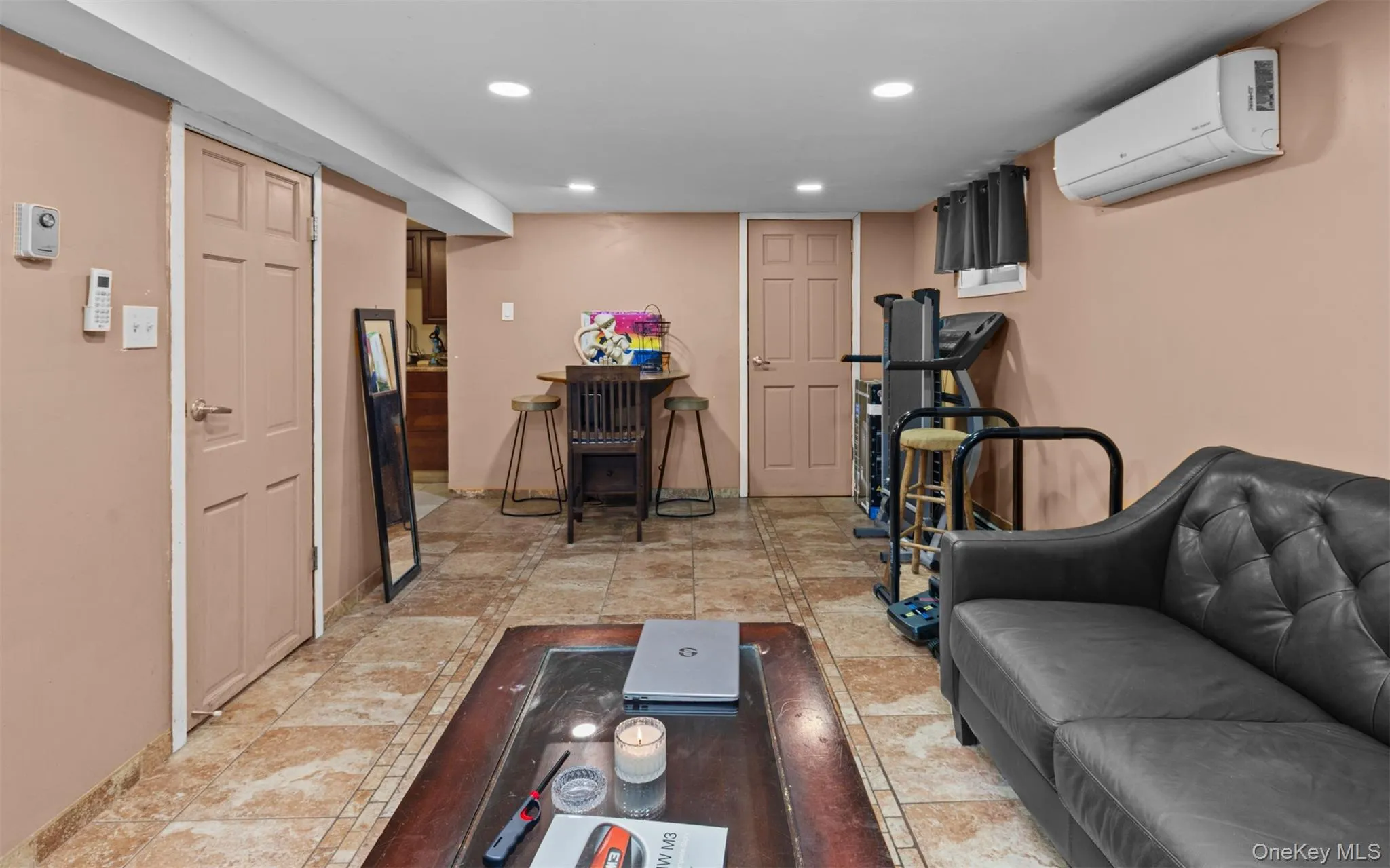Living room with recessed lighting, a wall unit AC, and light tile patterned floors Living room with recessed lighting, a wall unit AC, and light tile patterned floors