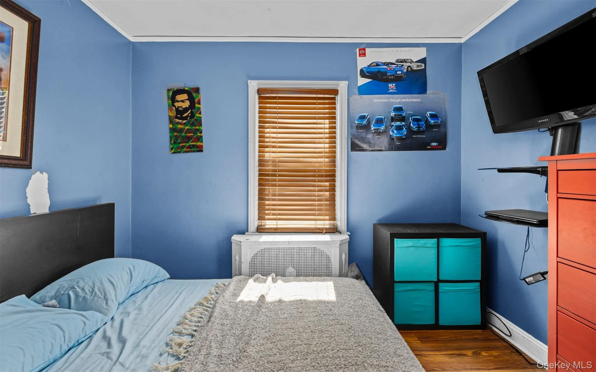 Bedroom with dark wood-type flooring, crown molding, and radiator heating unit Bedroom with dark wood-type flooring, crown molding, and radiator heating unit