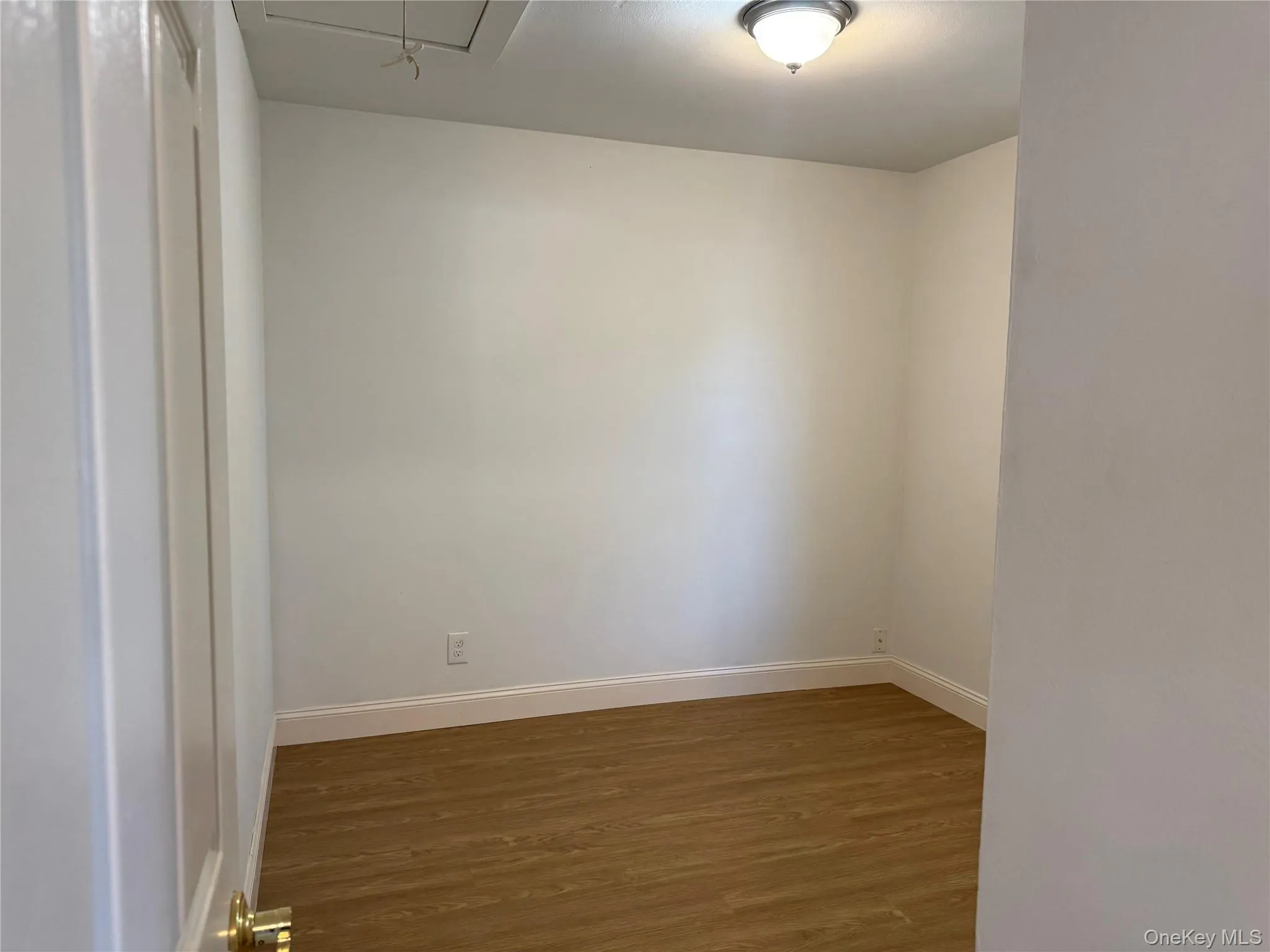 Unfurnished room featuring dark wood-type flooring and attic access Unfurnished room featuring dark wood-type flooring and attic access