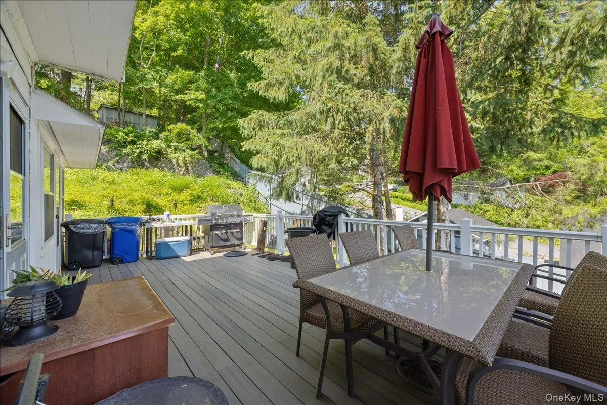 Wooden terrace featuring outdoor dining area and grilling area Wooden terrace featuring outdoor dining area and grilling area