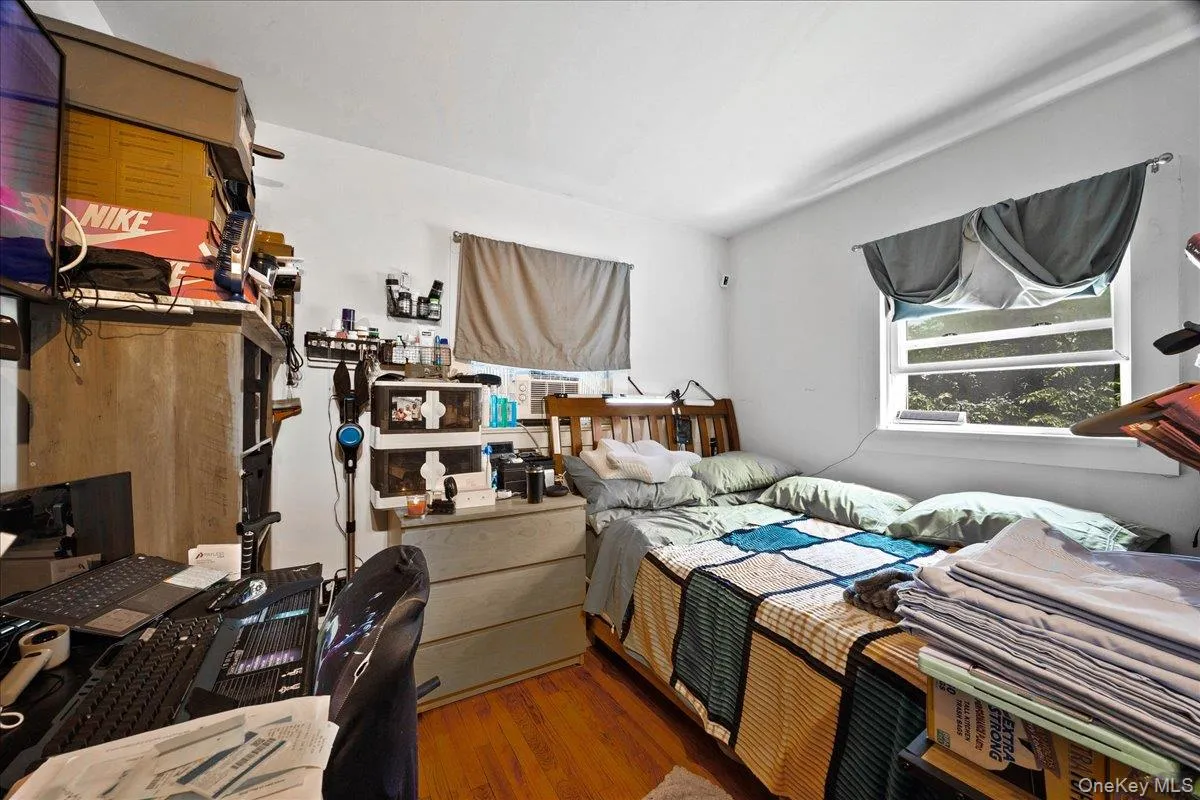 Bedroom featuring wood finished floors and a desk Bedroom featuring wood finished floors and a desk