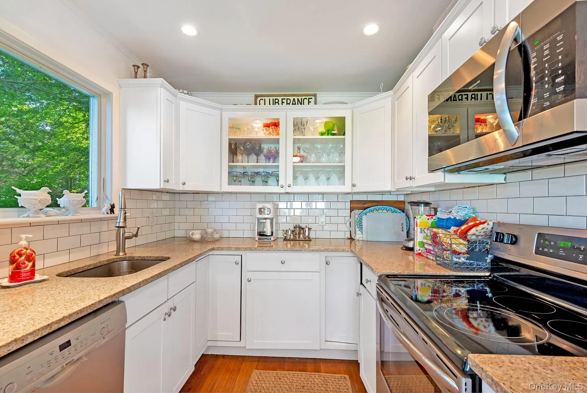 Kitchen with stainless steel appliances, white cabinets, light stone countertops, recessed lighting, and crown molding Kitchen with stainless steel appliances, white cabinets, light stone countertops, recessed lighting, and crown molding